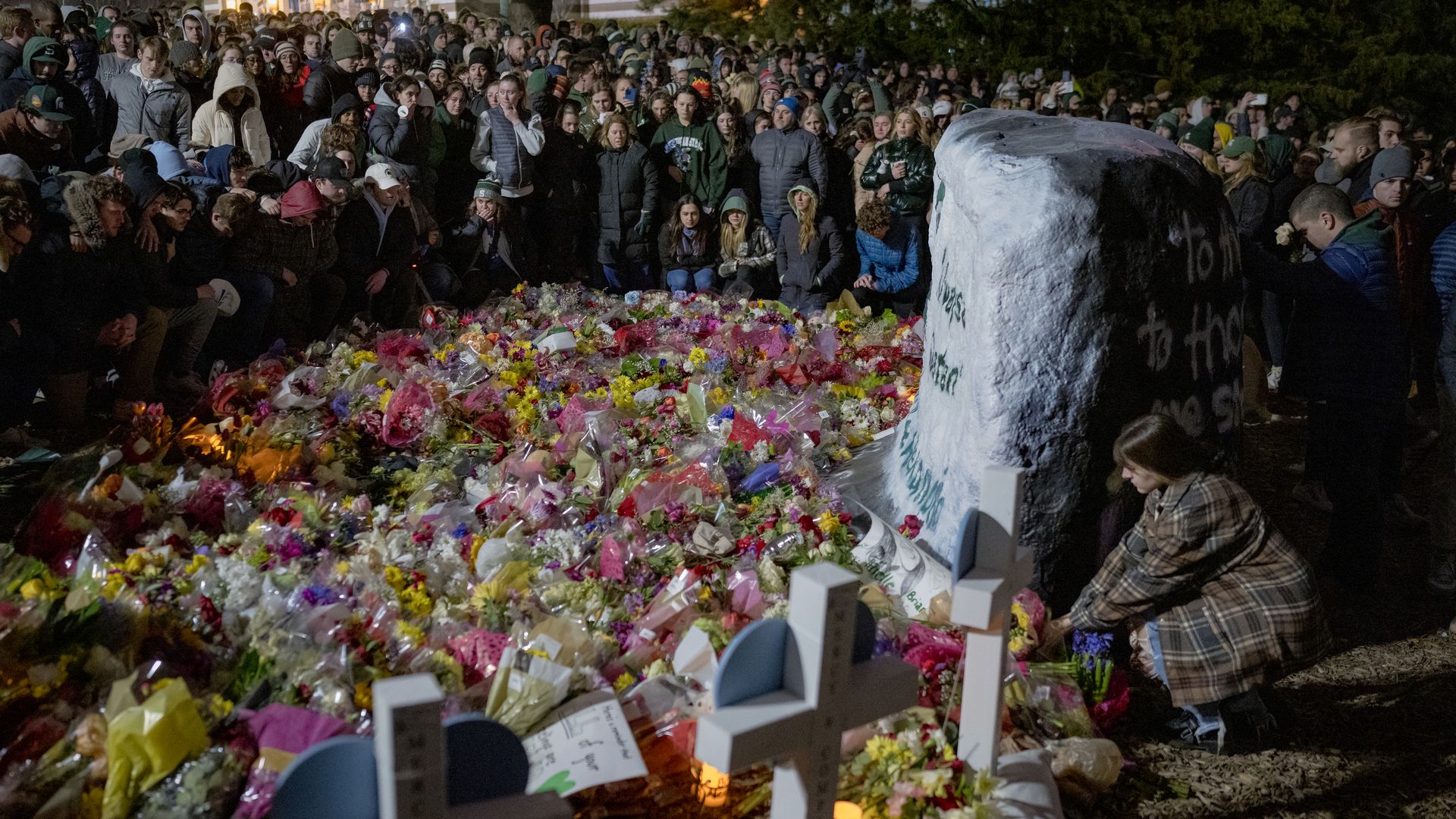 People gathered around a memorial on Michigan State University's campus in East Lansing, Michigan, on Feb. 15. for the three people killed and five hospitalized from the shooting. 