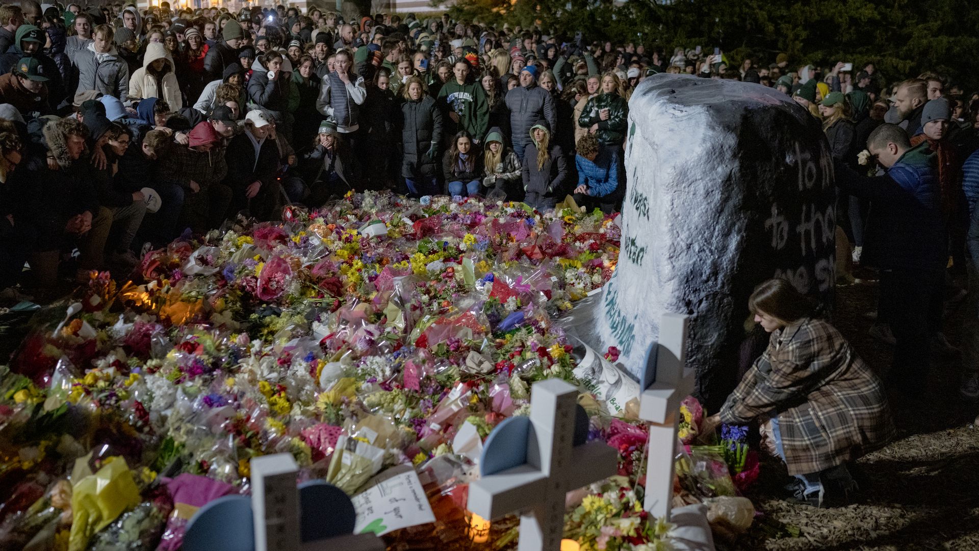 People gathered around a memorial on Michigan State University's campus in East Lansing, Michigan, on Feb. 15. for the three people killed and five hospitalized from the shooting.