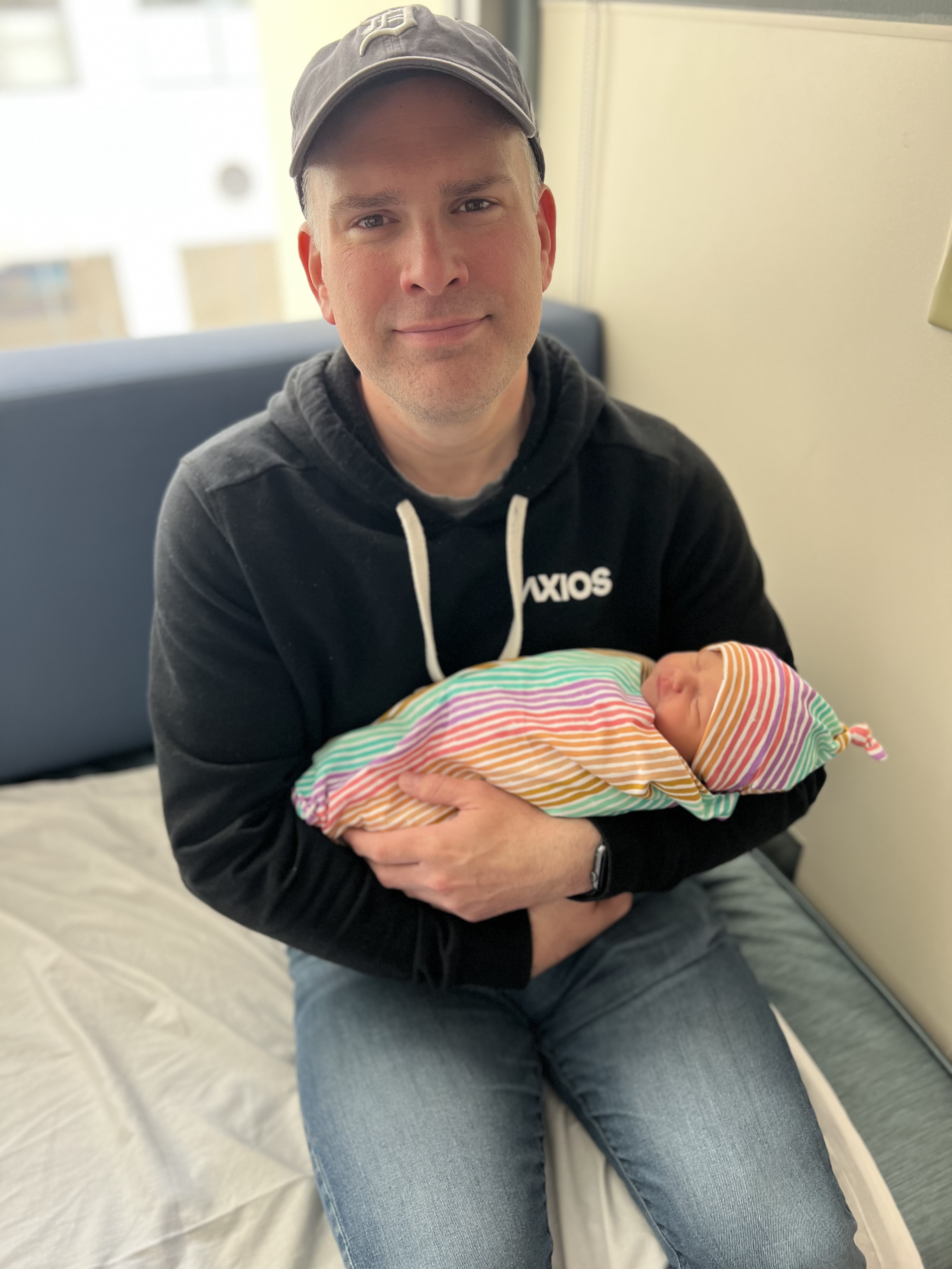 James Briggs holds his daughter, Meredith, in a rainbow-colored swaddle in the hospital after her birth.