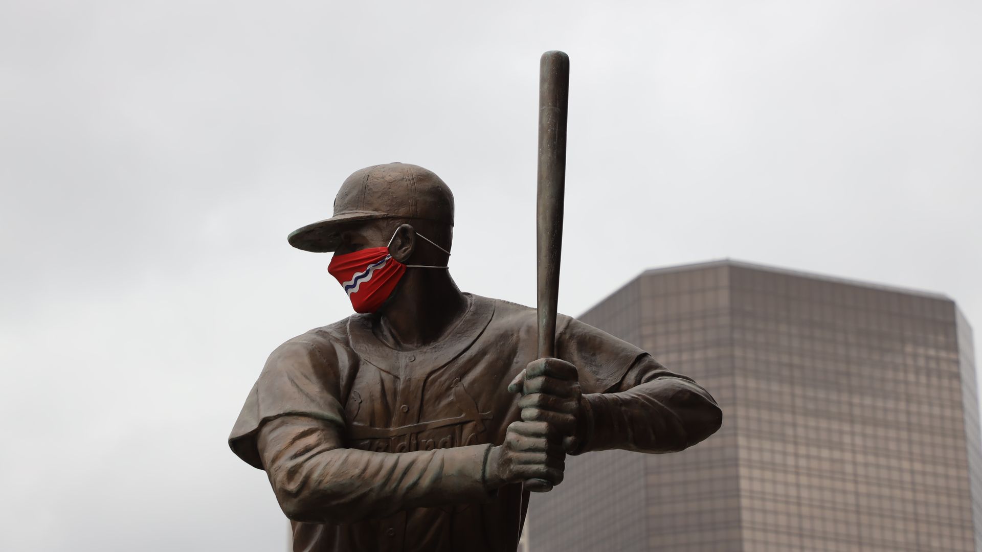 The Stan Musial statue outside Busch Stadium in St. Louis wearing a mask with the city's flag on it in April 2021.