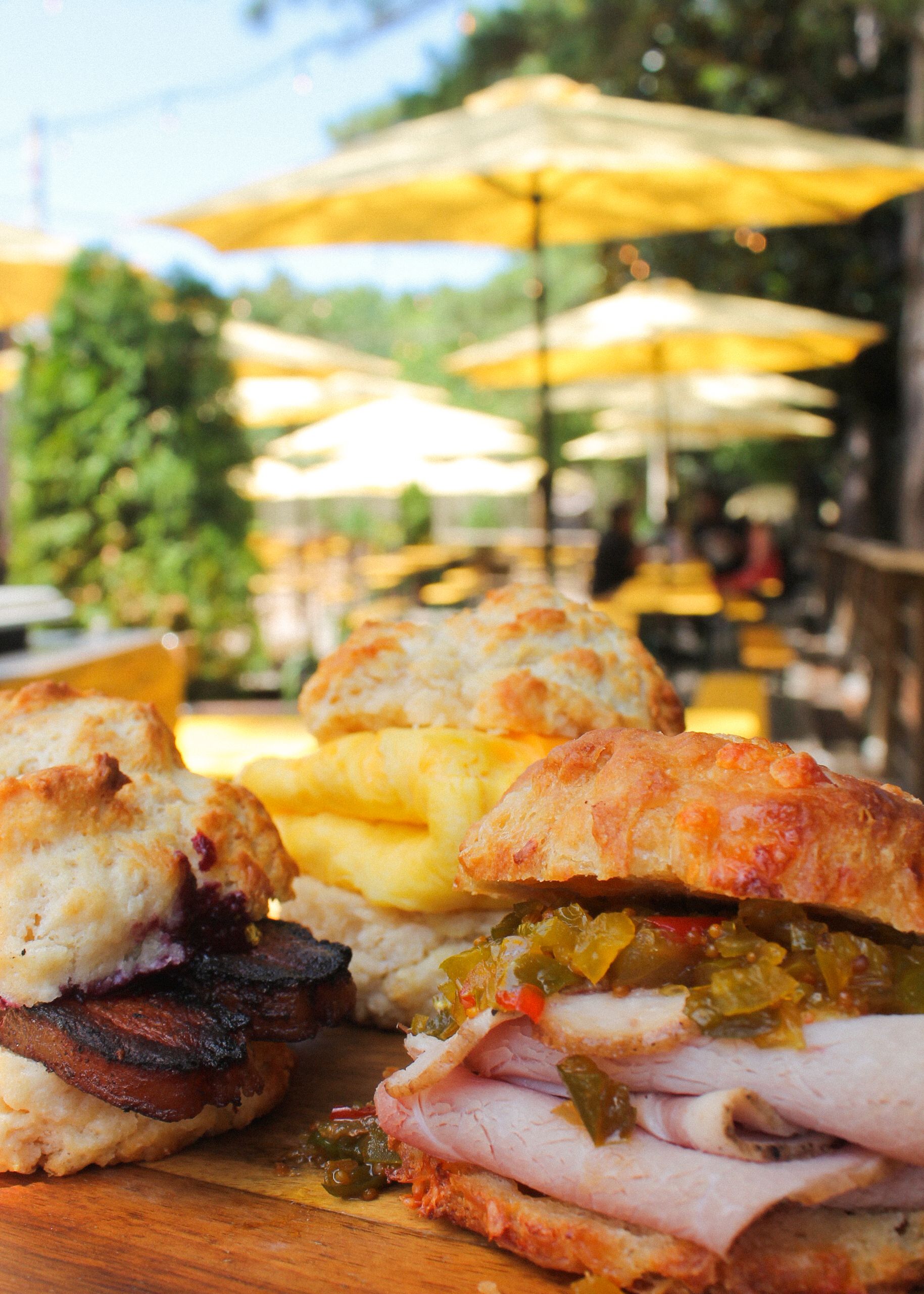 Images of a City Ham & Chow Chow Cheddar Biscuit, Egg and Cheese Biscuit, and House Pork Belly Bacon and Jam Biscuit