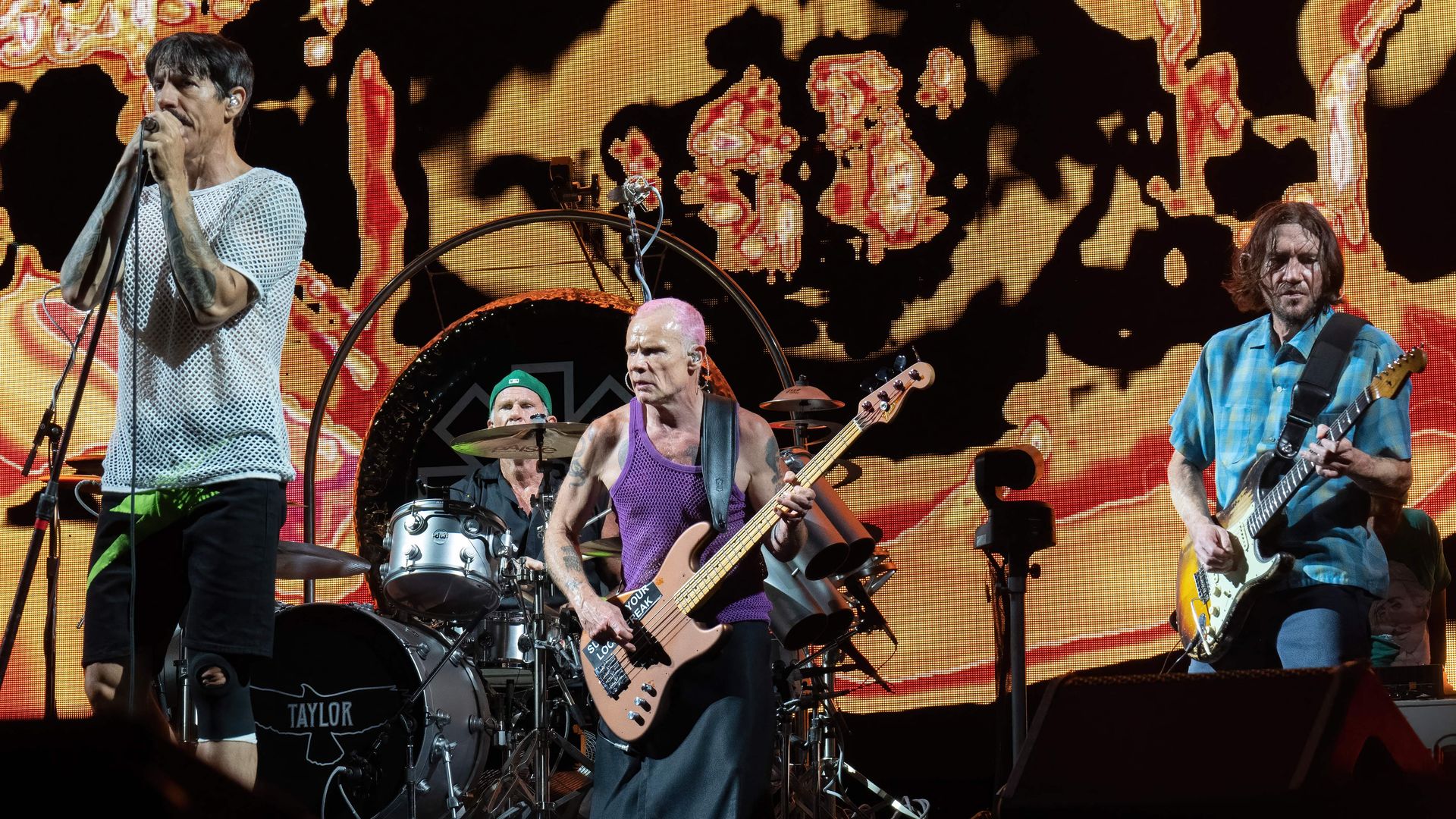Members of the Red Hot Chili Peppers band perform on stage. 