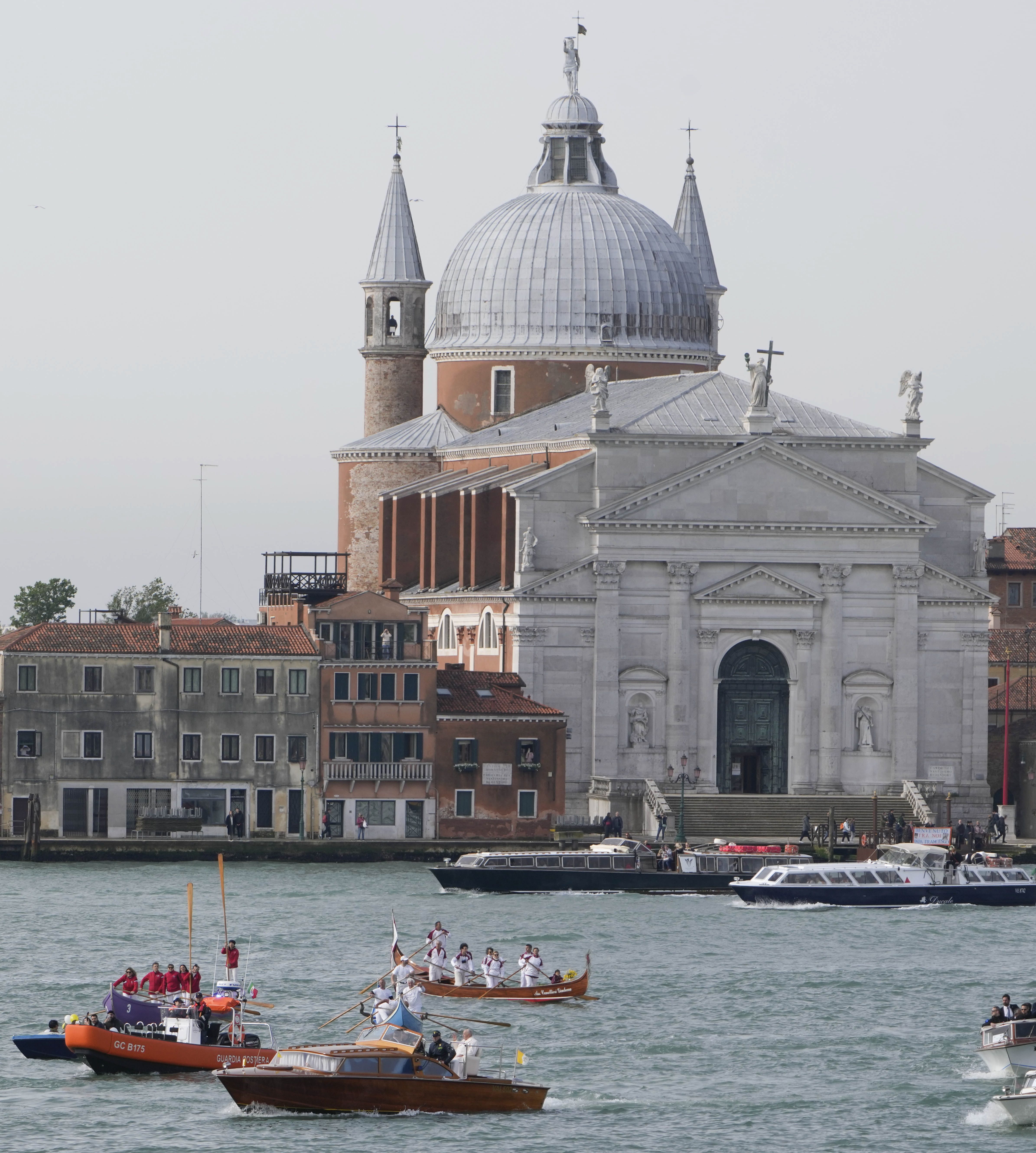 Pope Francis, foreground, is greeted by Gondoliers upon his arrival in Venice, Italy, Sunday, April 28, 2024. The Pontiff arrived for his first-ever visit to the lagoon town including the Vatican pavilion at the 60th Biennal of Arts. In background is the Church of the Most Holy Redeemer. 