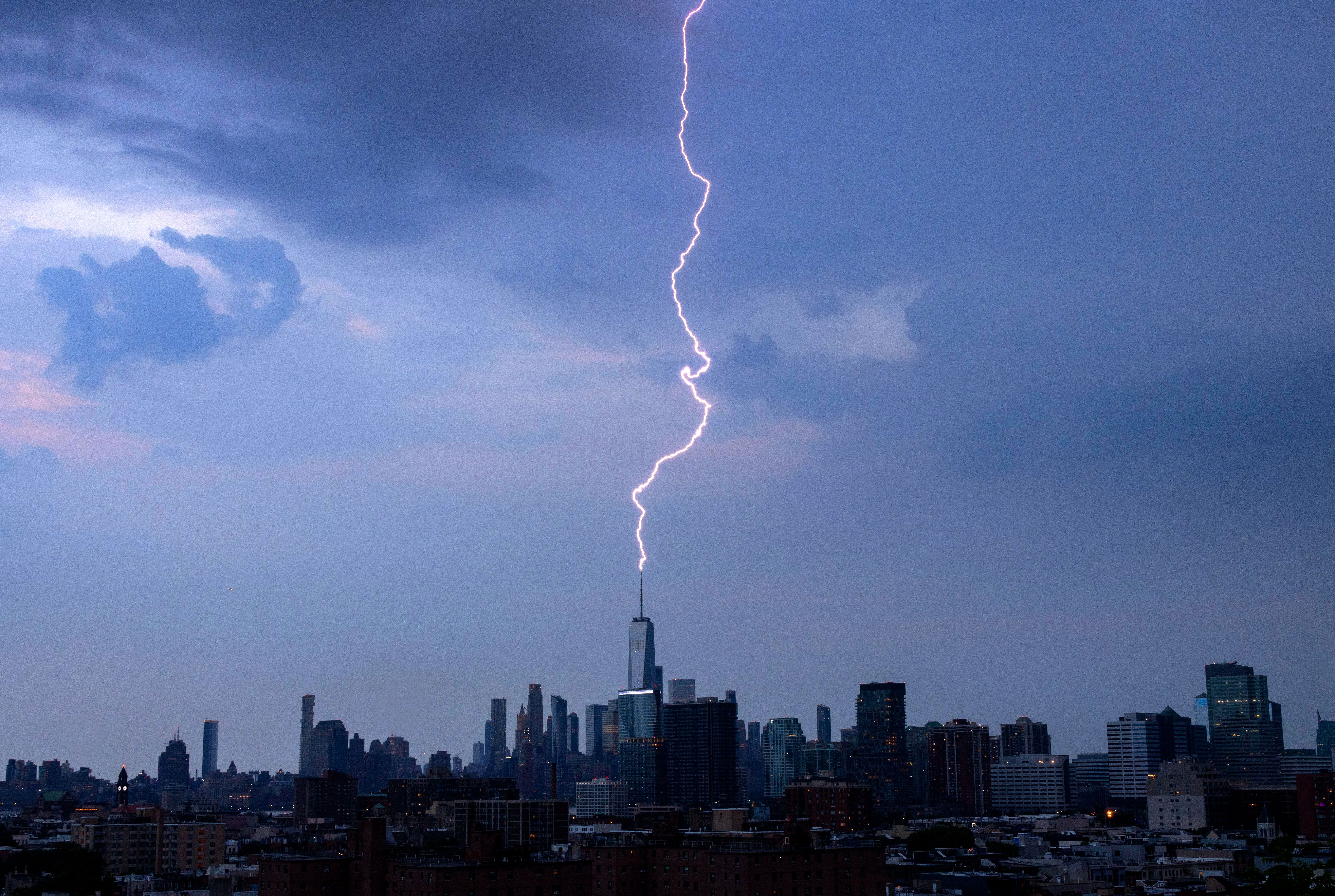 A lightning bolt strikes One World Trade Center during a thunderstorm in New York City on June 22, 2024, as seen from Jersey City, New Jersey.