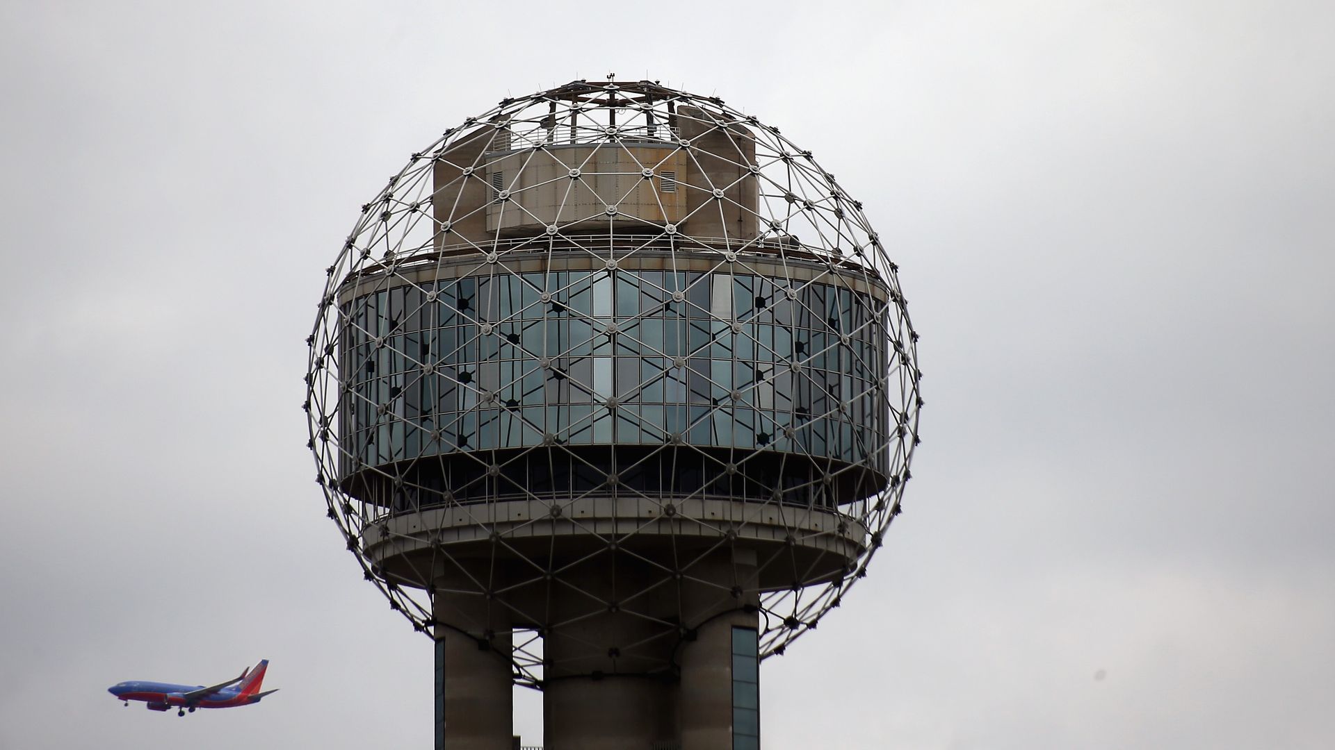 A plane flies to the left of Reunion Tower in Dallas. 