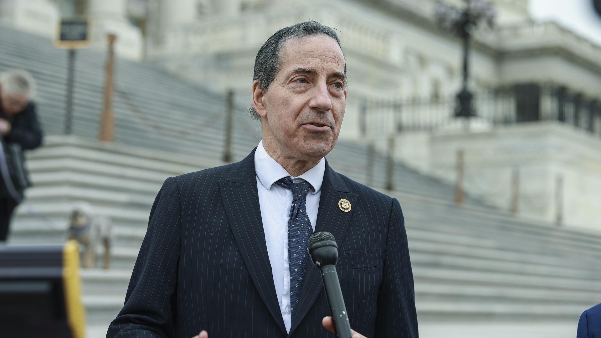 Rep. Jamie Raskin, wearing a dark blue pinstripe suit, white shirt and blue tie.