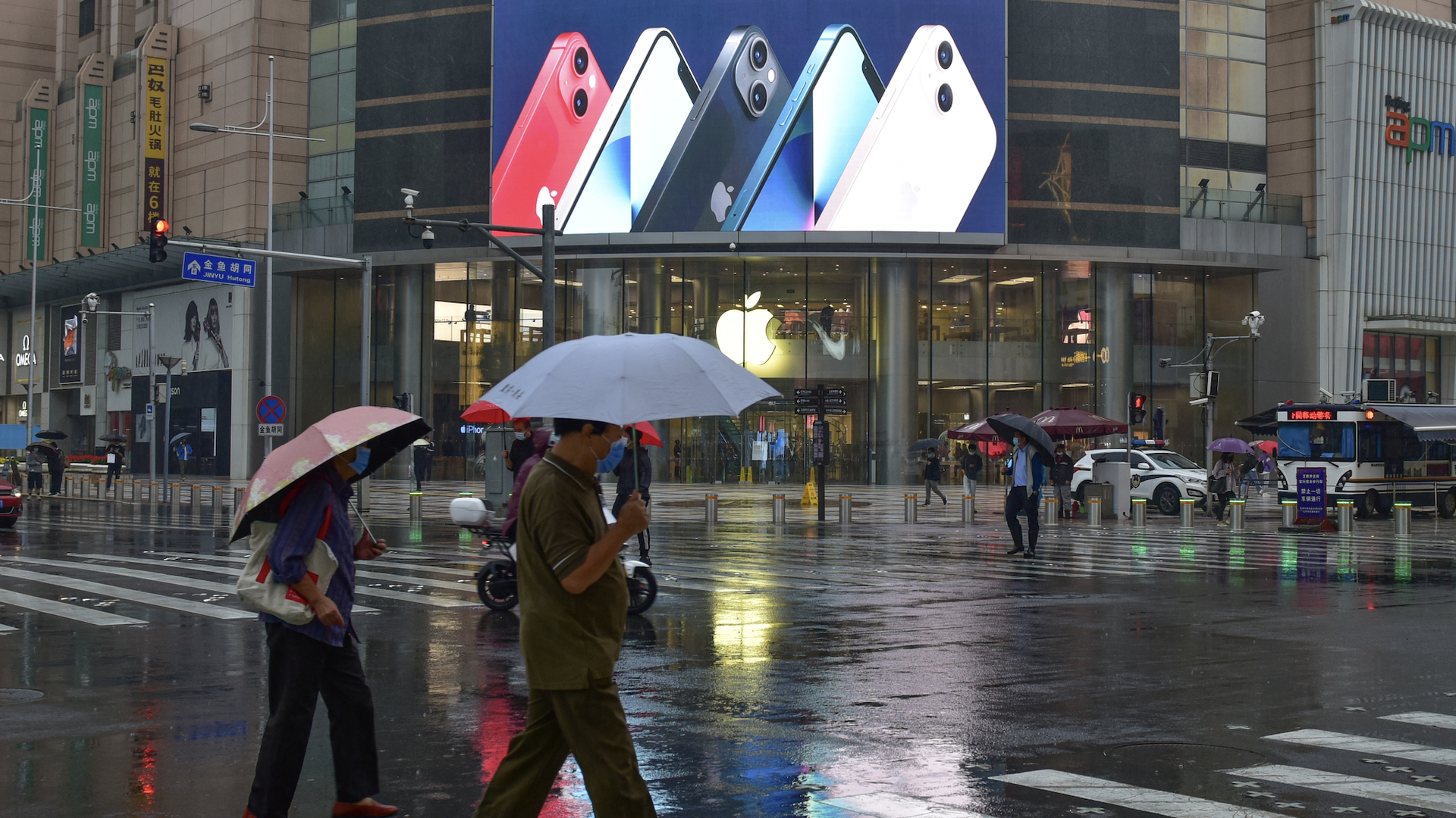 People walk past an advertisement for the new iPhone 13 series in Beijing. 