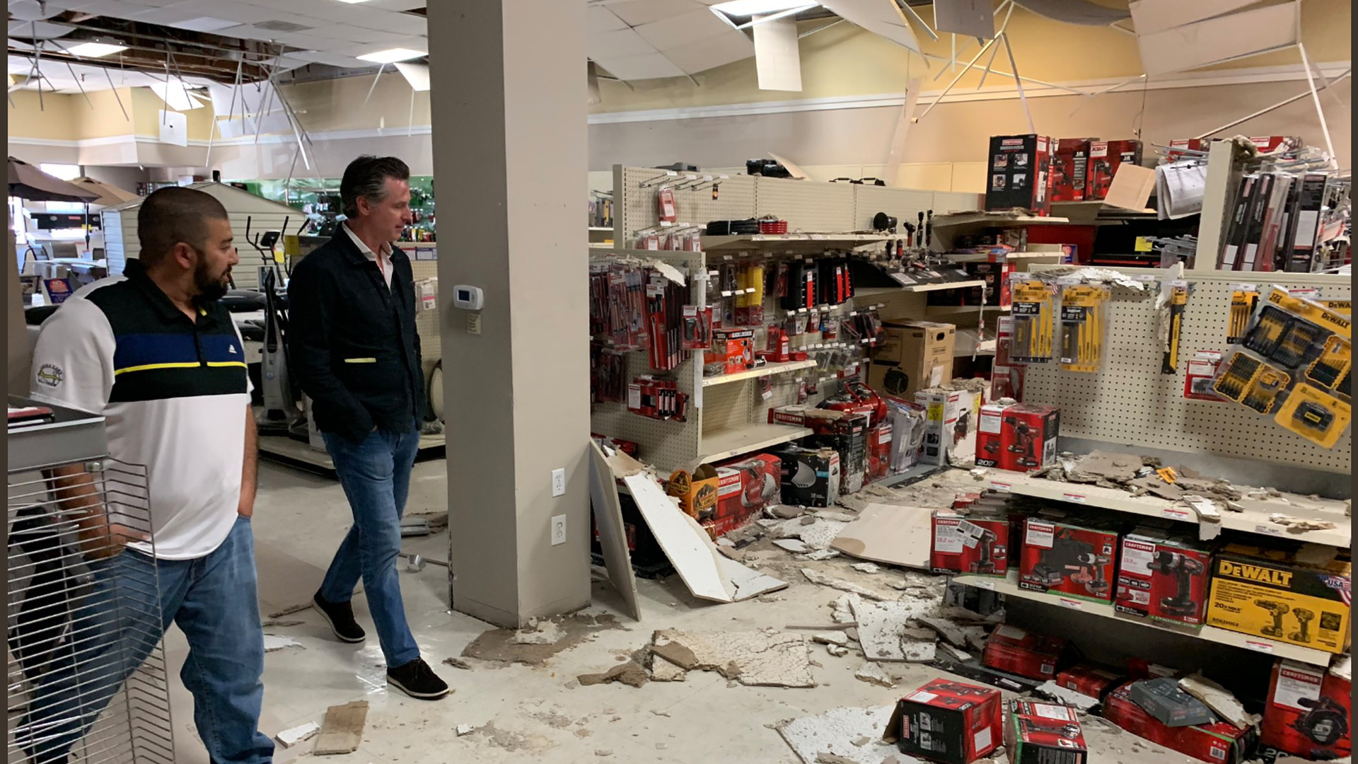 California Gov. Gavin Newsom assesses the quake damage in a store.