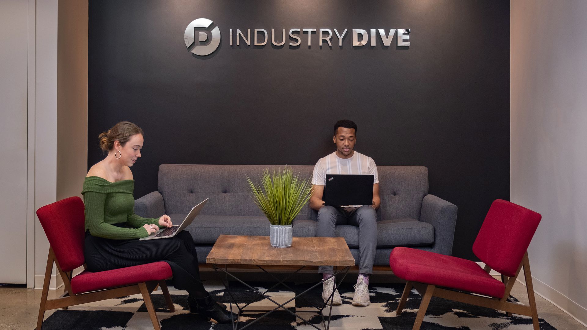 Two people sit on chairs under a logo that says "Industry Dive" 
