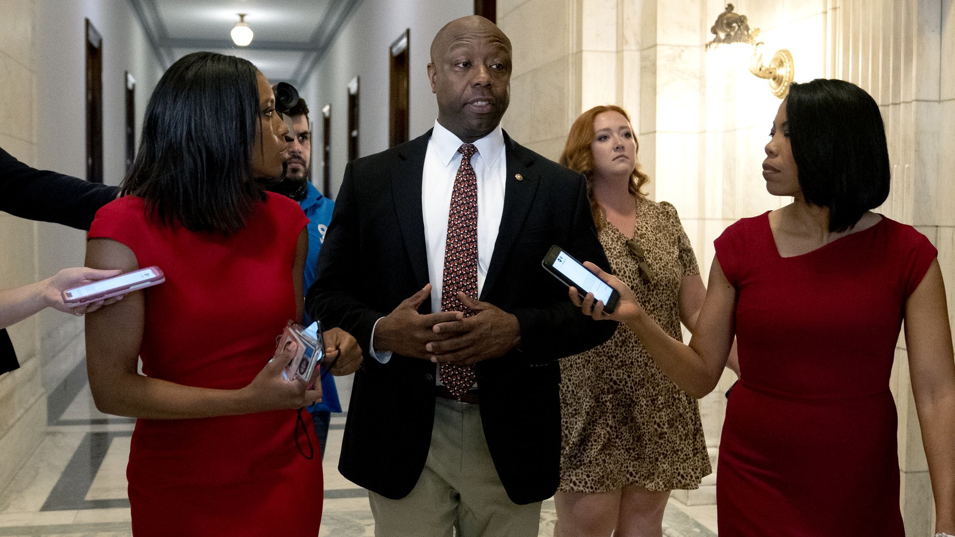 Sen. Tim Scott is seen speaking with reporters as he walks through the Russell Office Building.