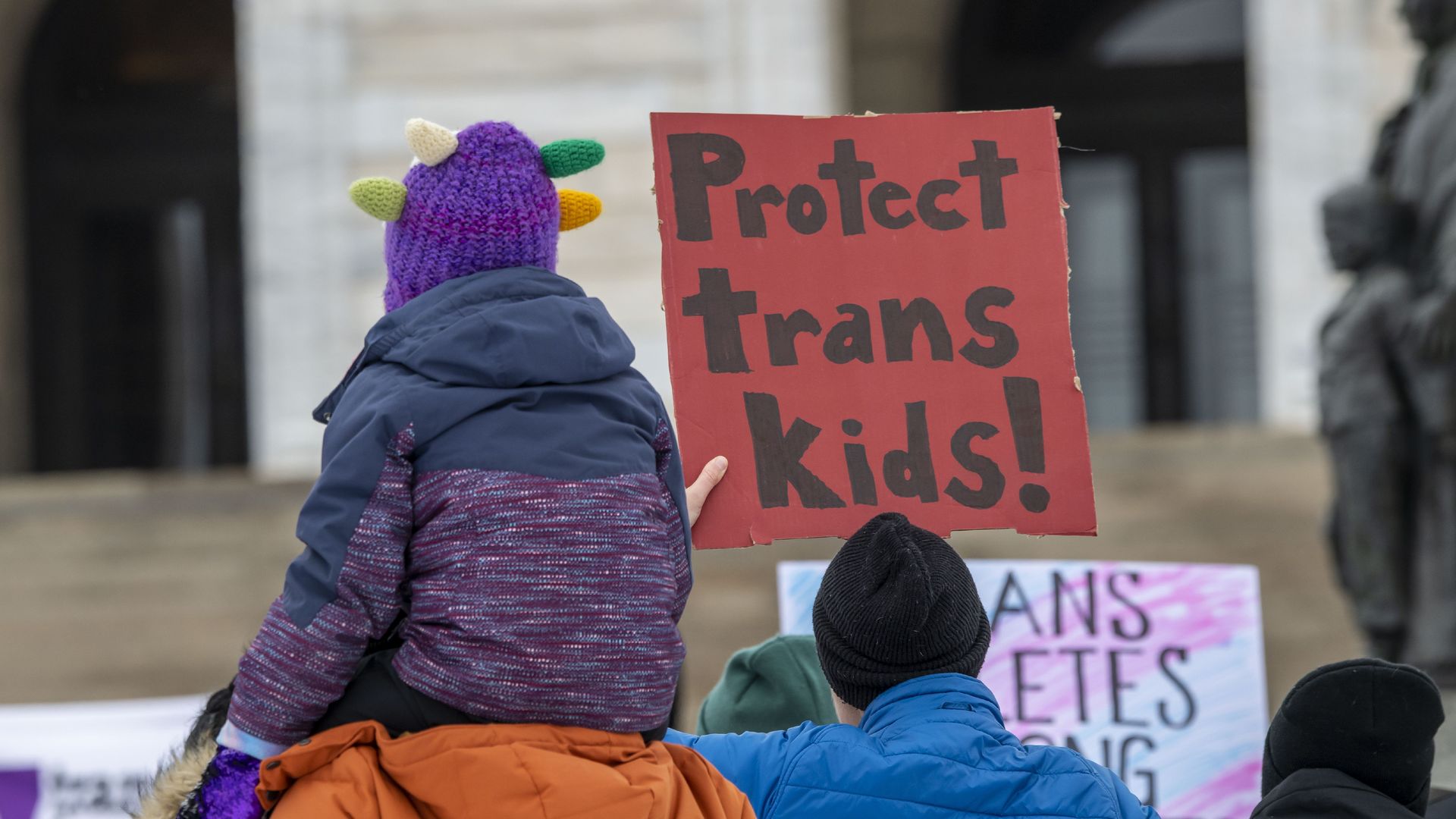 Picture of a sign that says "protect trans kids!"