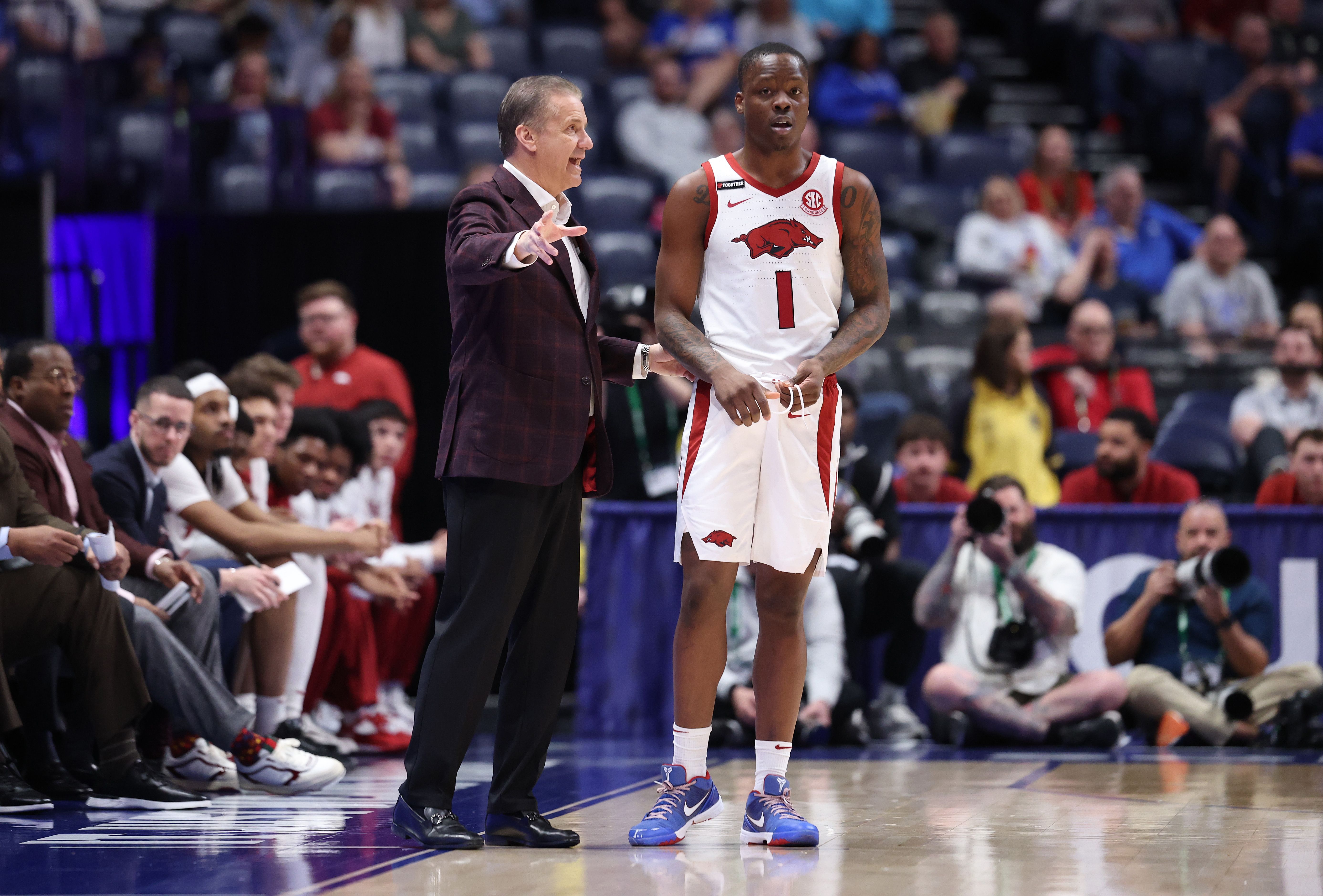 Photo of a coach talking to a basketball player on the court 