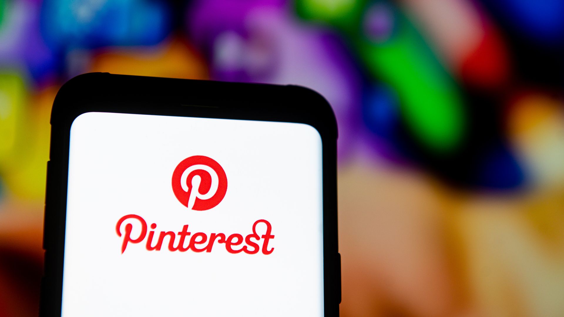 The Pinterest logo is displayed on a smartphone.