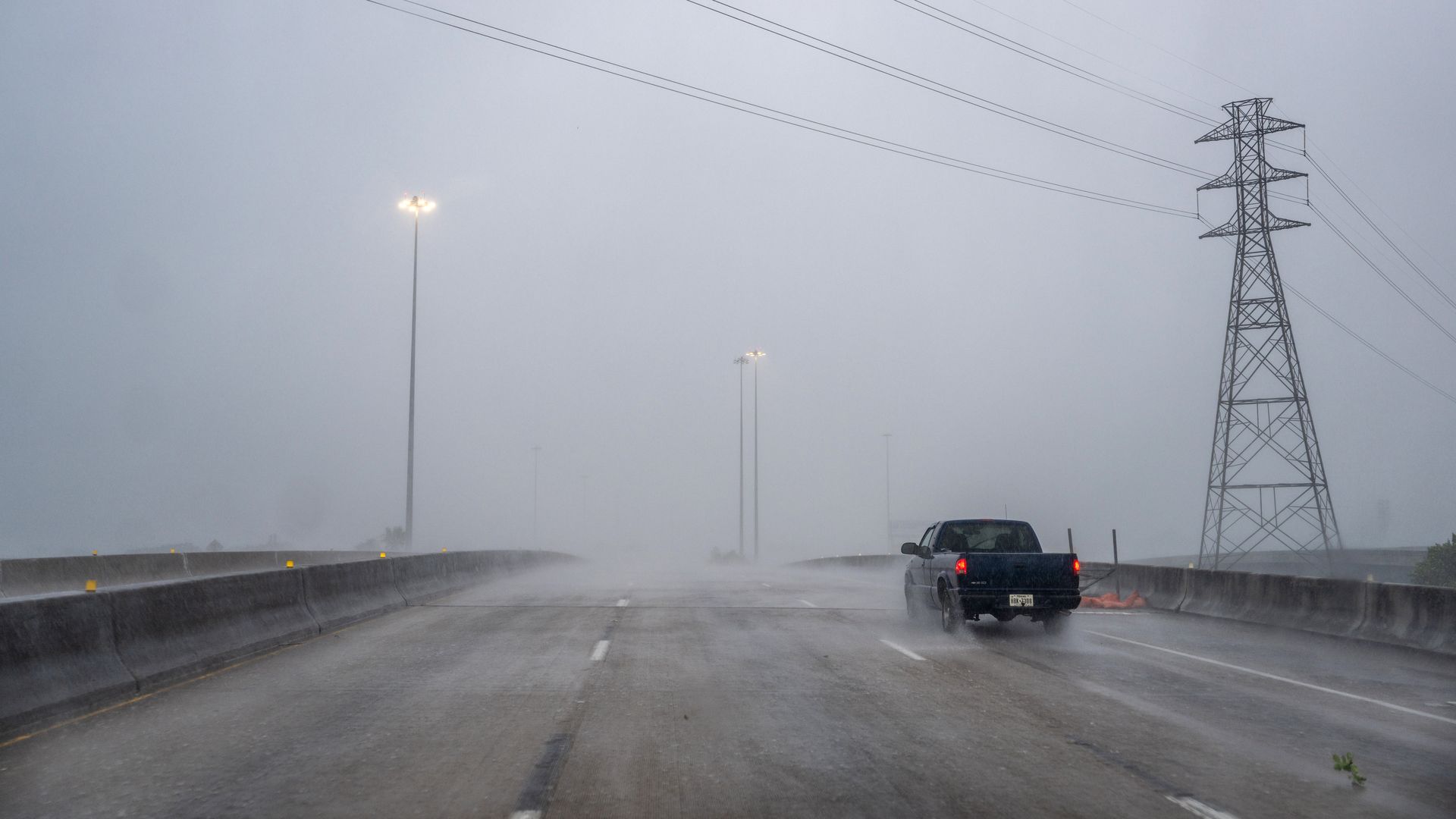 A pickup driver navigates a rainy freeway in Houston