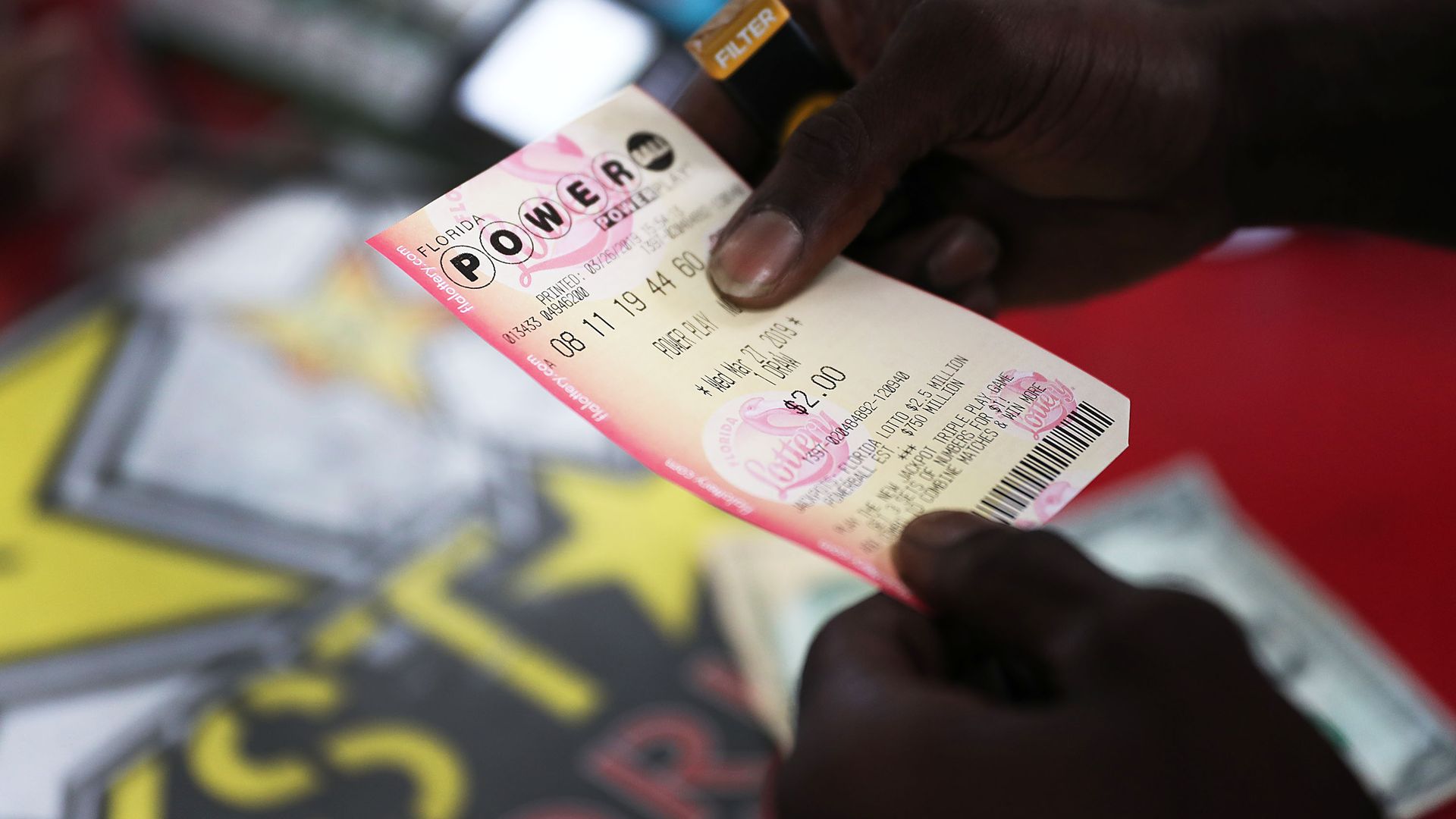 Hands holding a Powerball lottery ticket