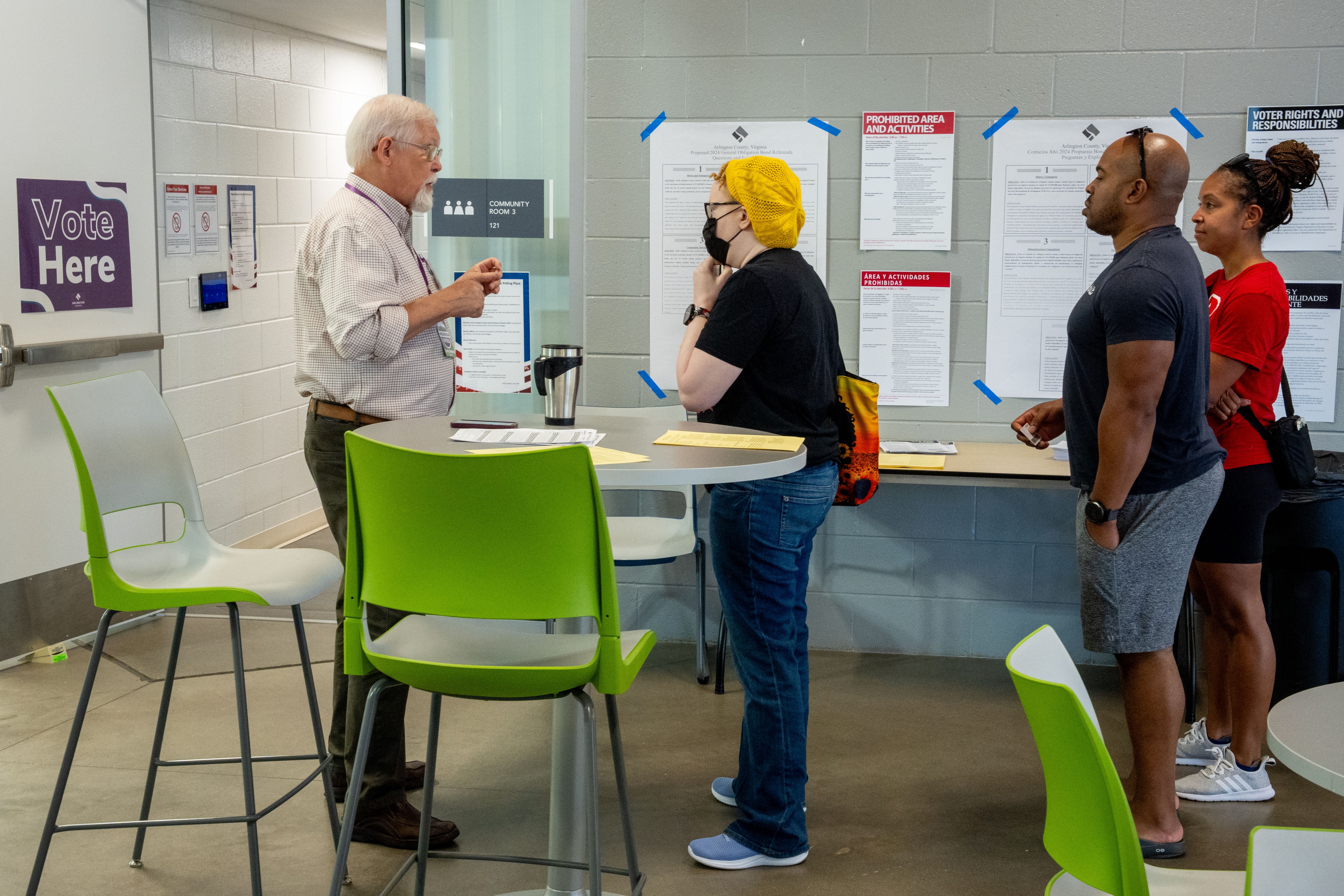 A poll worker speaks to people as they arrive to vote on the first day of Virginia's in-person early voting at Long Bridge Park Aquatics and Fitness Center on September 20, 2024 in Arlington, Virginia. Ballots have started being cast for the presidential race and local elections in Virginia, Minneso