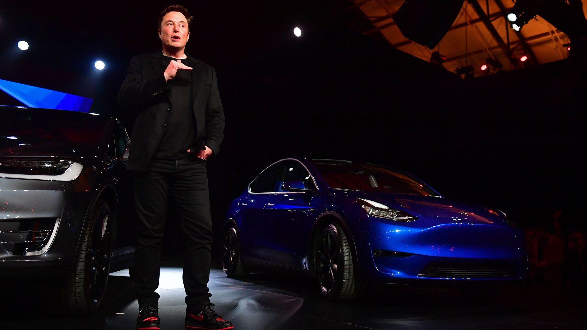 Elon Musk speaks beside the just unveiled new Tesla Model Y (R) in Hawthorne, California on March 14, 2019.