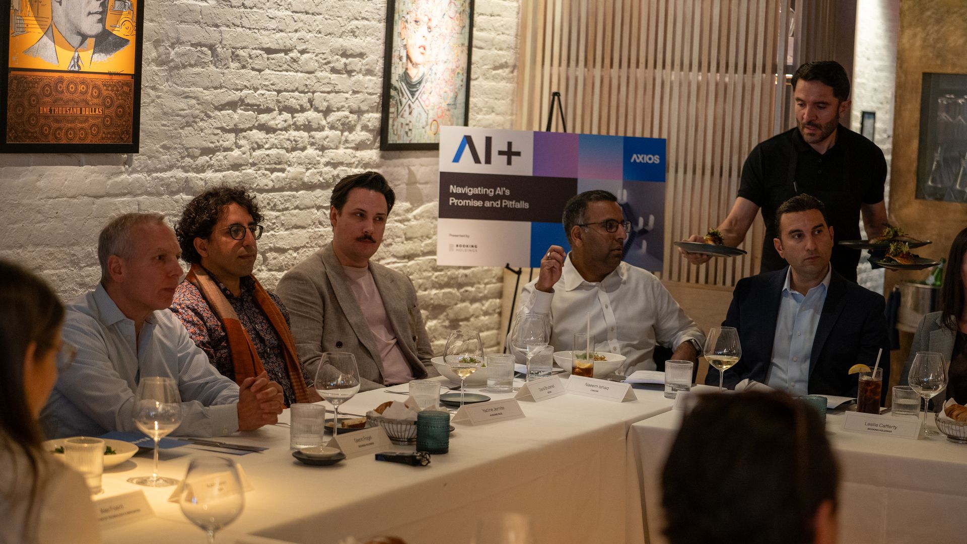 Attendees sit around the table, listening during the discussion.