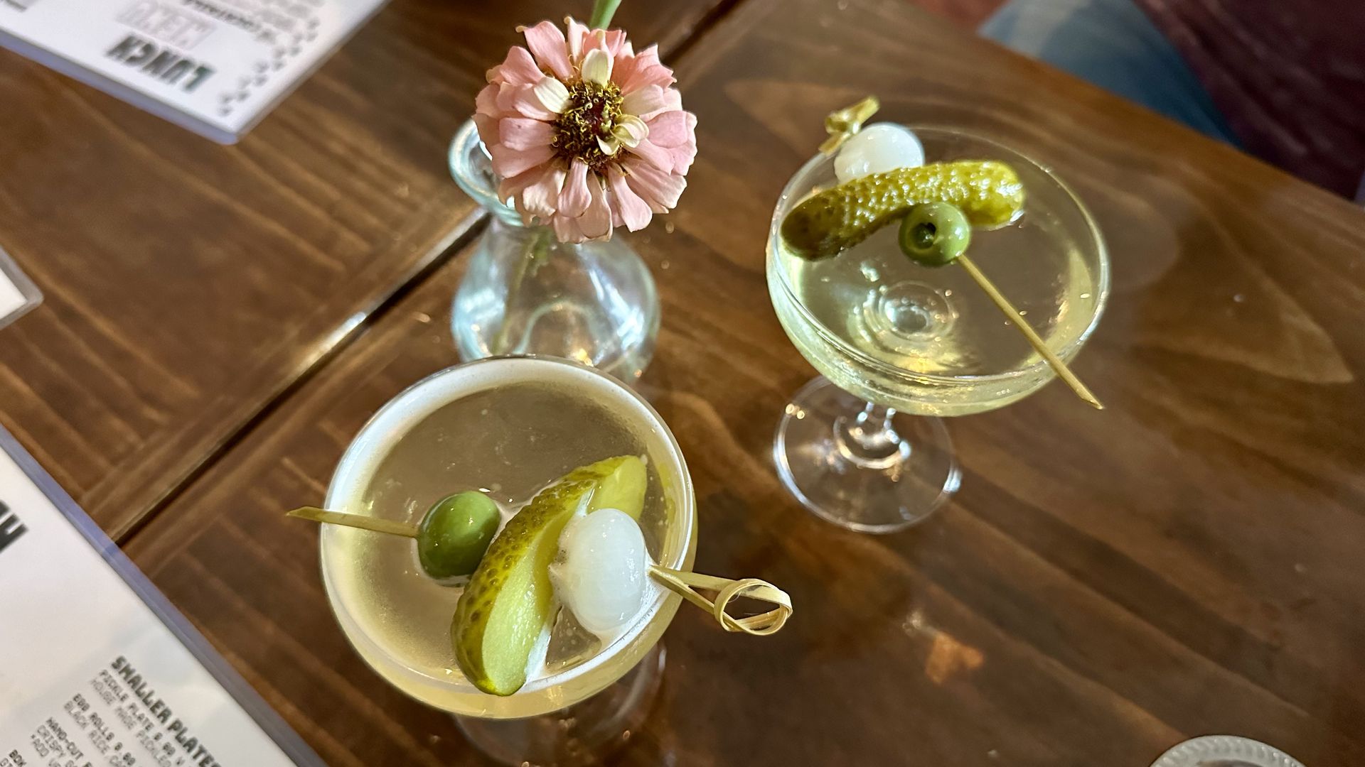 photo shows 2 pickle martinis on a table with flowers