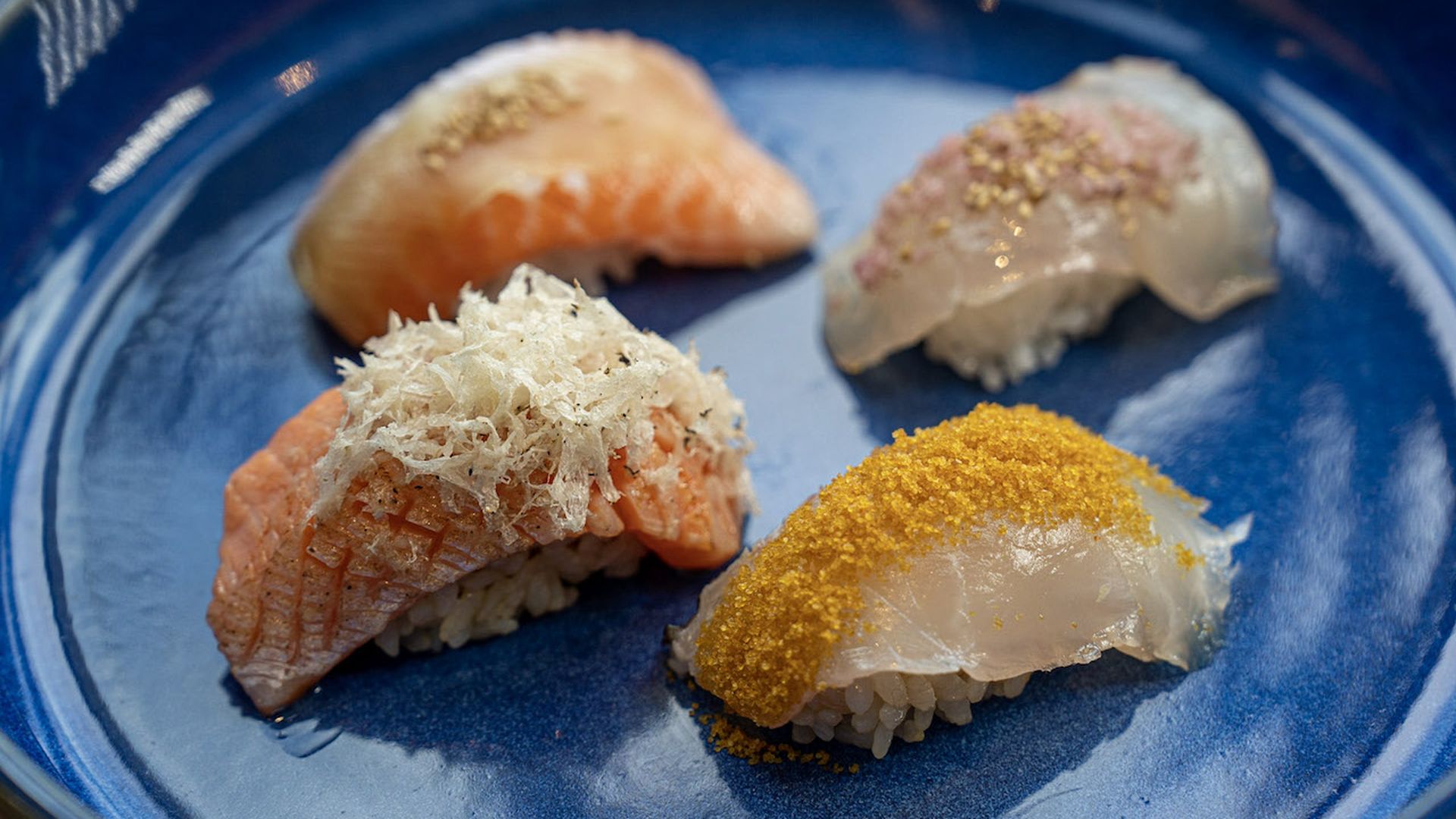 Four pieces of sushi on a blue plate