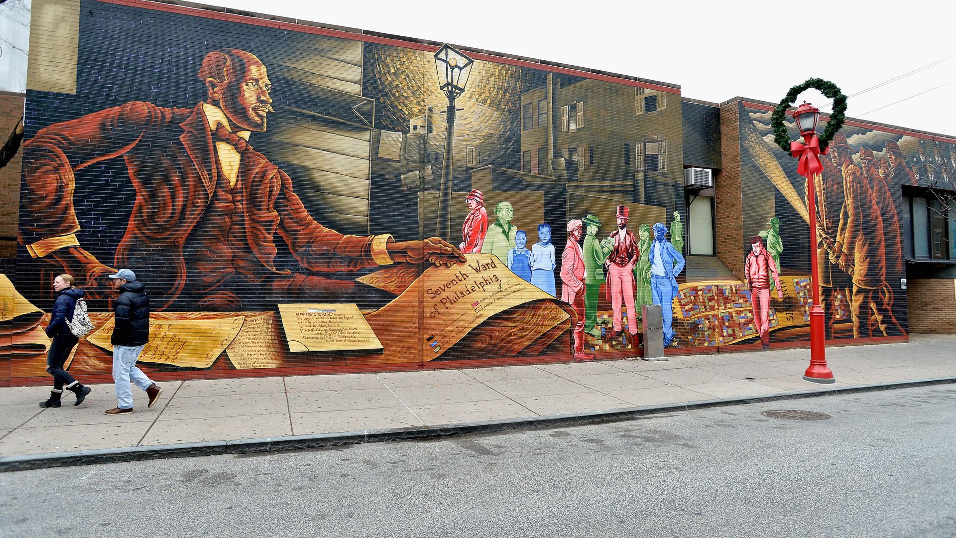 A mural of a man holding a scroll that says. "Seventh Ward of Philadelphia," on South Street.