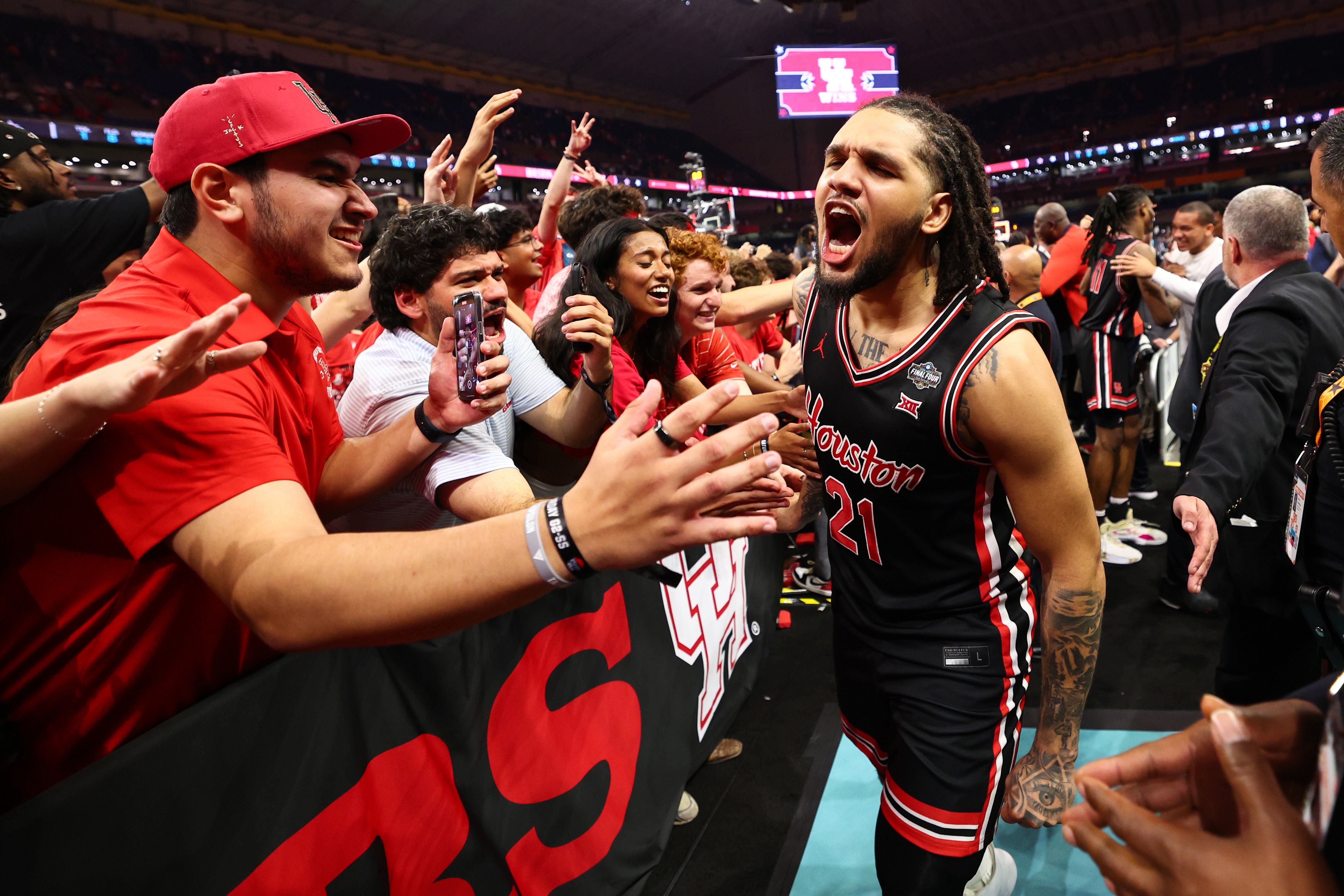 Emanuel Sharp #21 of the Houston Cougars celebrates by slapping fans' hands.