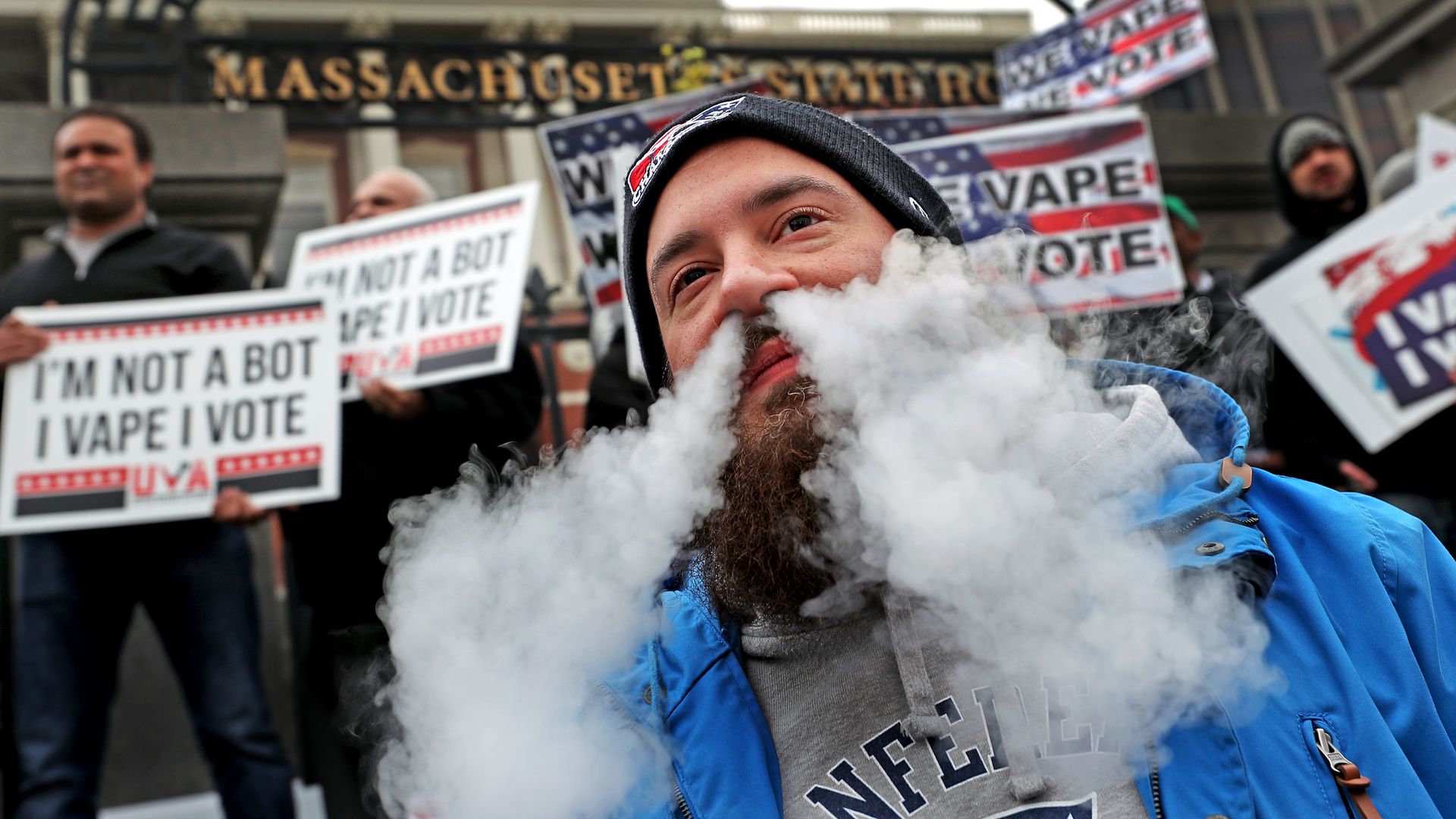 vapes in protest during a demonstration against Massachusetts Governor Charlie Baker's vaping ban on the front steps of the Massachusetts State House 