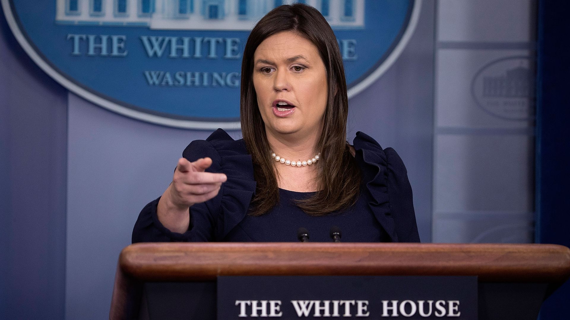 Sarah Sanders points to a reporter while speaking at the podium