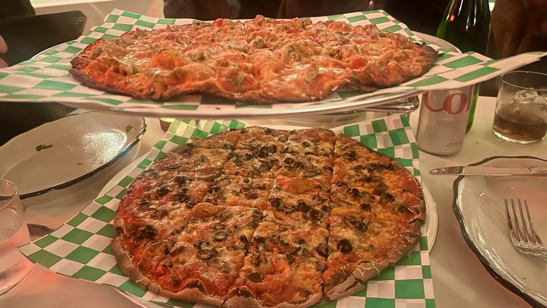 Photo of two pizzas tacked on a table 