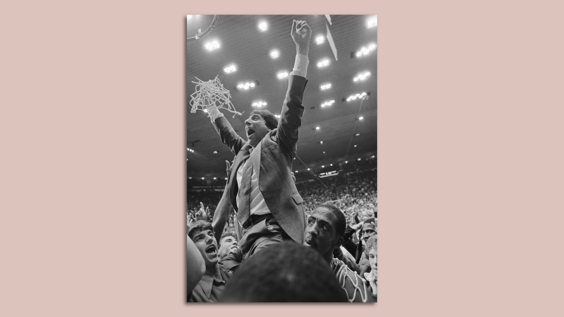 NC State Coach Jim Valvano holds the net in celebration. 