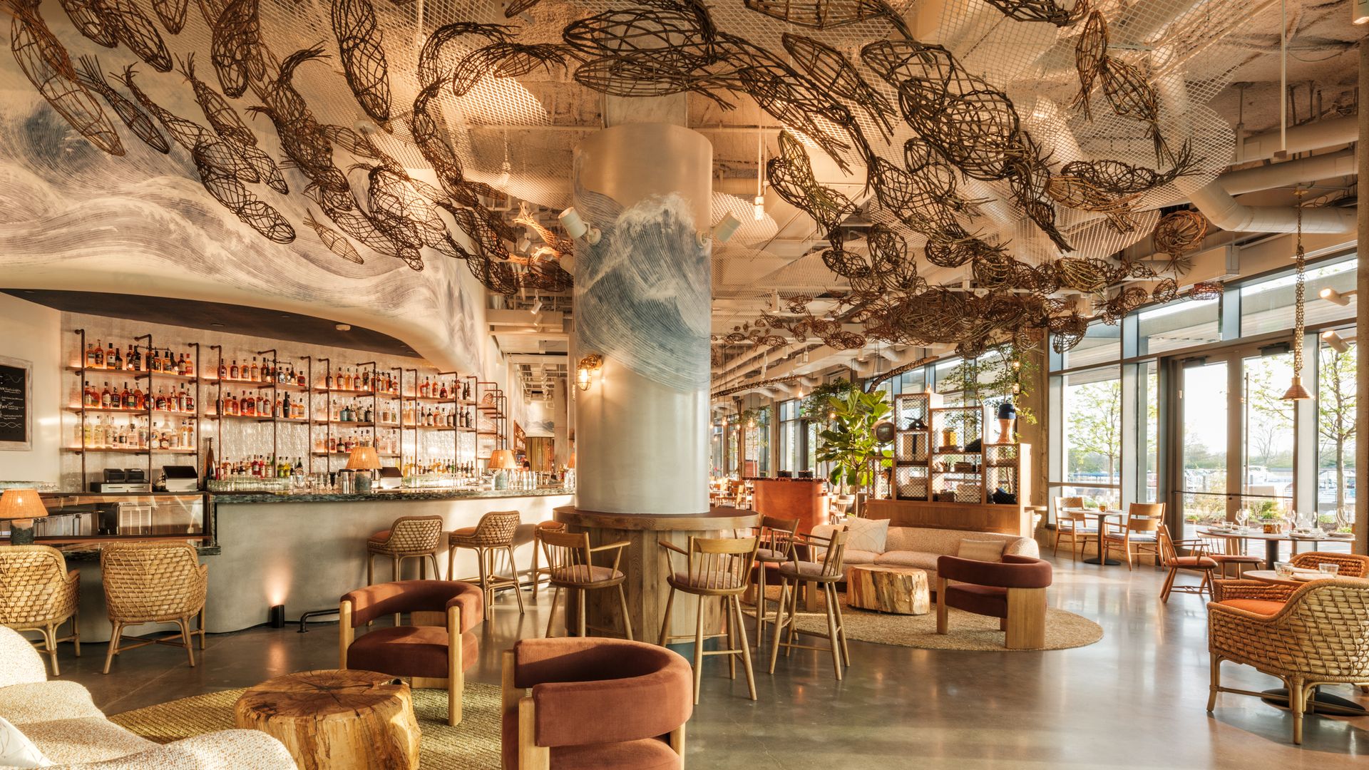 Fish Shop dining room with woven chairs and a school of fish art installation