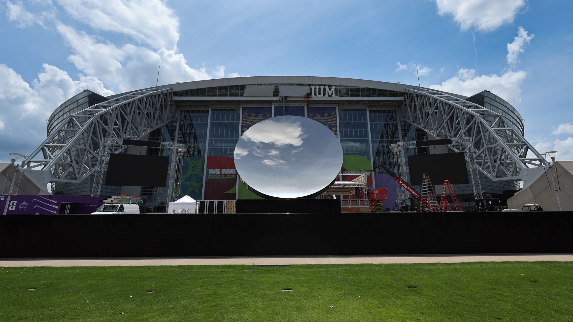 A daytime view of AT&T Stadium most of the stadium's name covered up by tarp