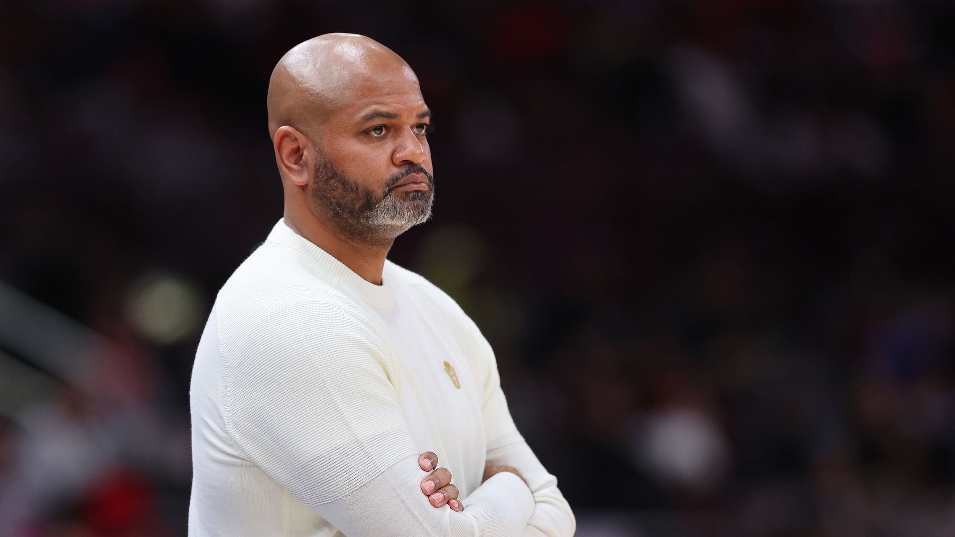 Cavs' head coach JB Bickerstaff in a white shirt with arms crossed on the the sideline.