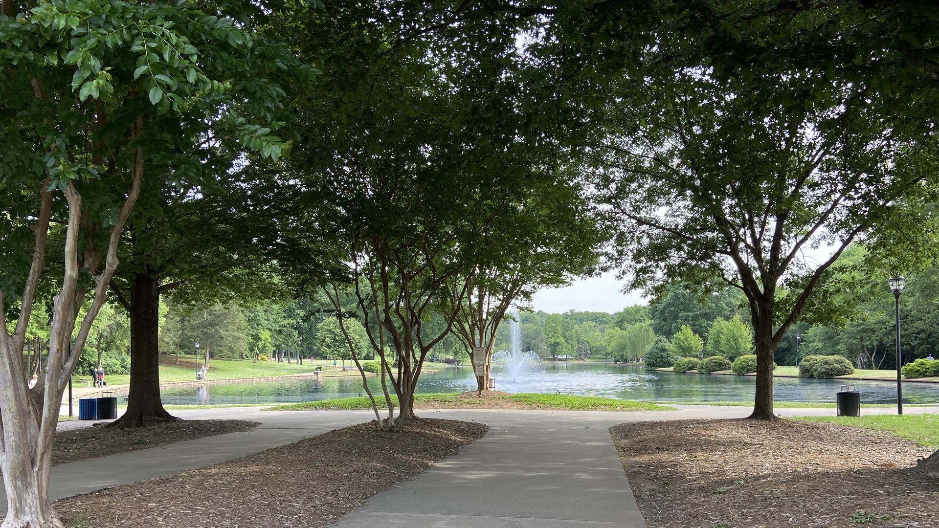 Freedom Park entrance off Princeton Avenue. Trees are in full bloom. A fountain shoots out of the po