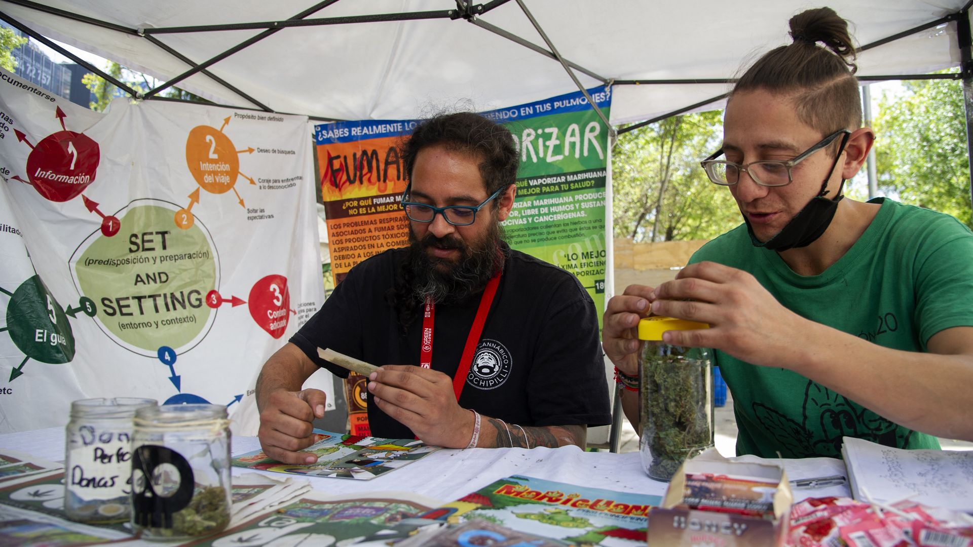 Photo of two people rolling marijuana joints
