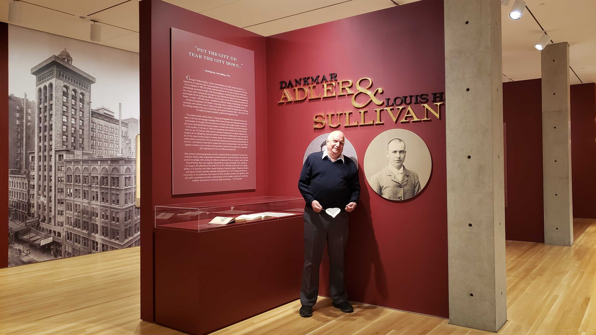 A photo of a man standing in front of a museum exhibit. 