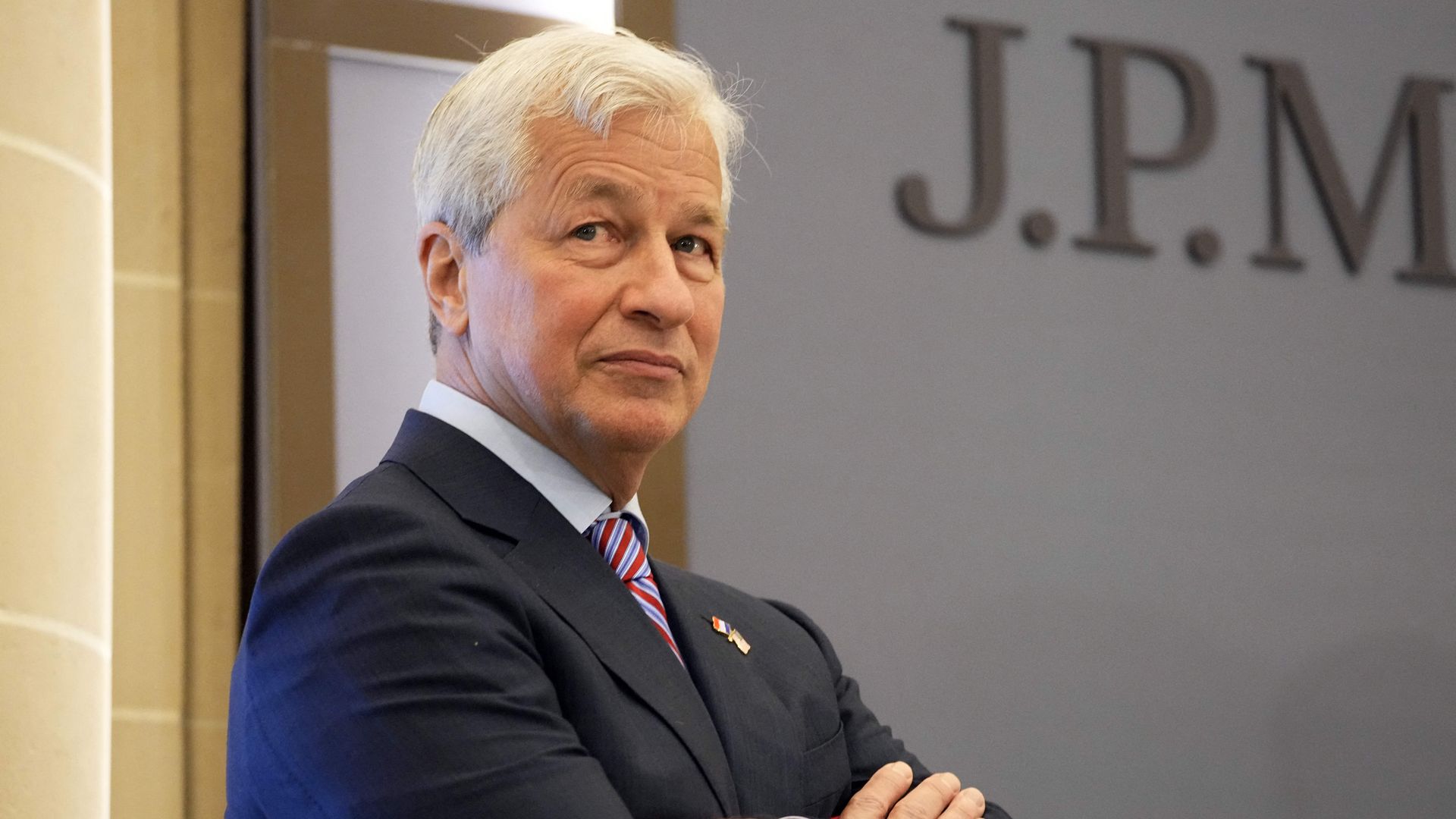 Jamie Dimon is seen standing with his arms crossed.