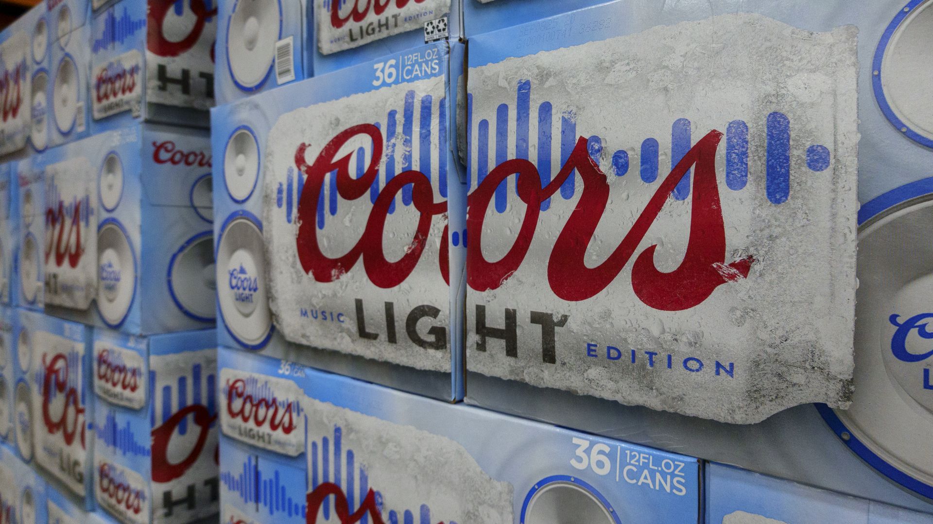 Stacked 36-pack cases of Coors Light beer, Music Edition, with blue and white packaging featuring a red Coors logo and soundwave graphic.