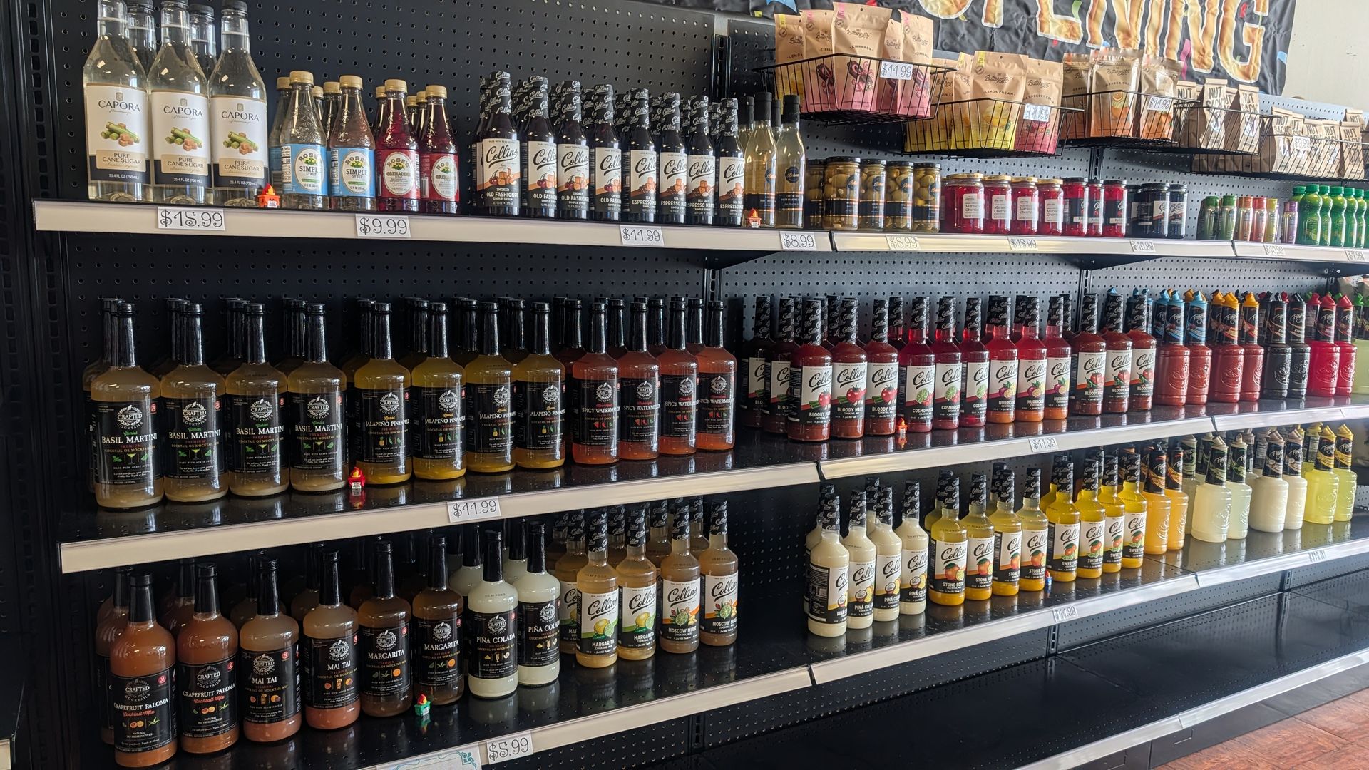 Rows of cocktail and mocktail mixers in bottles on store shelves 