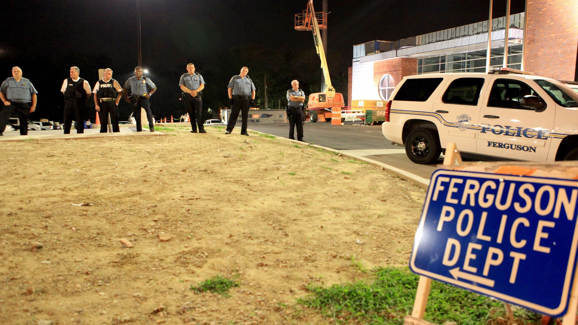 Police officers stand guard in front of the police station during a protest over the killing of unarmed teen Michael Brown in the Saint Louis suburb of Ferguson, Missouri.