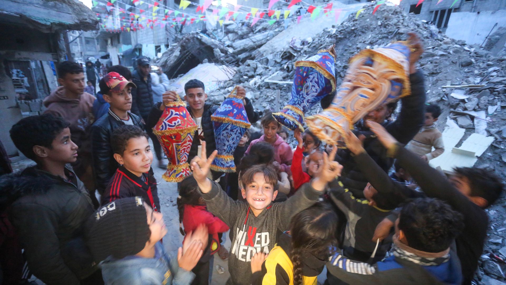 Group of children with one in the center with two fingers up with each hand