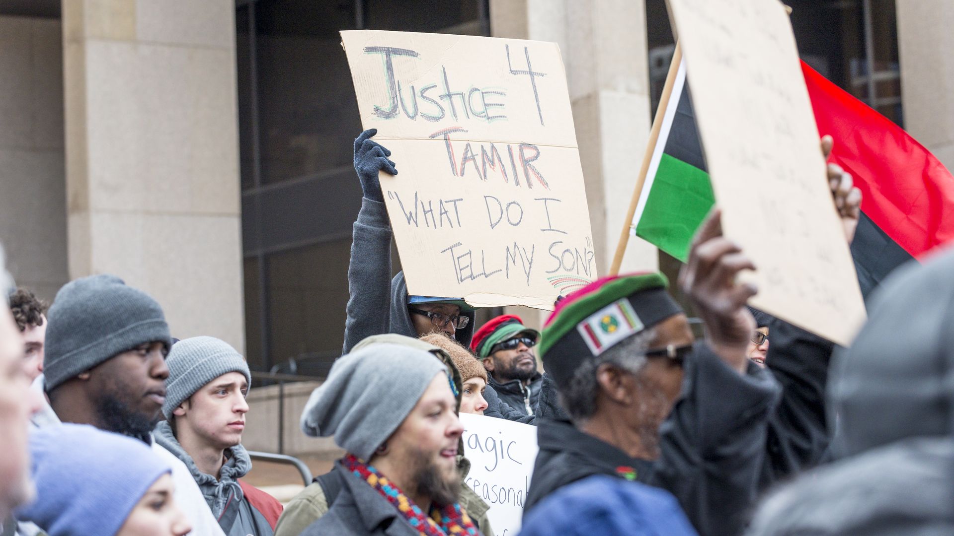 Photo of a person holding up a sign that says "Justice 4 Tamir. What do I tell my son?" at a protest