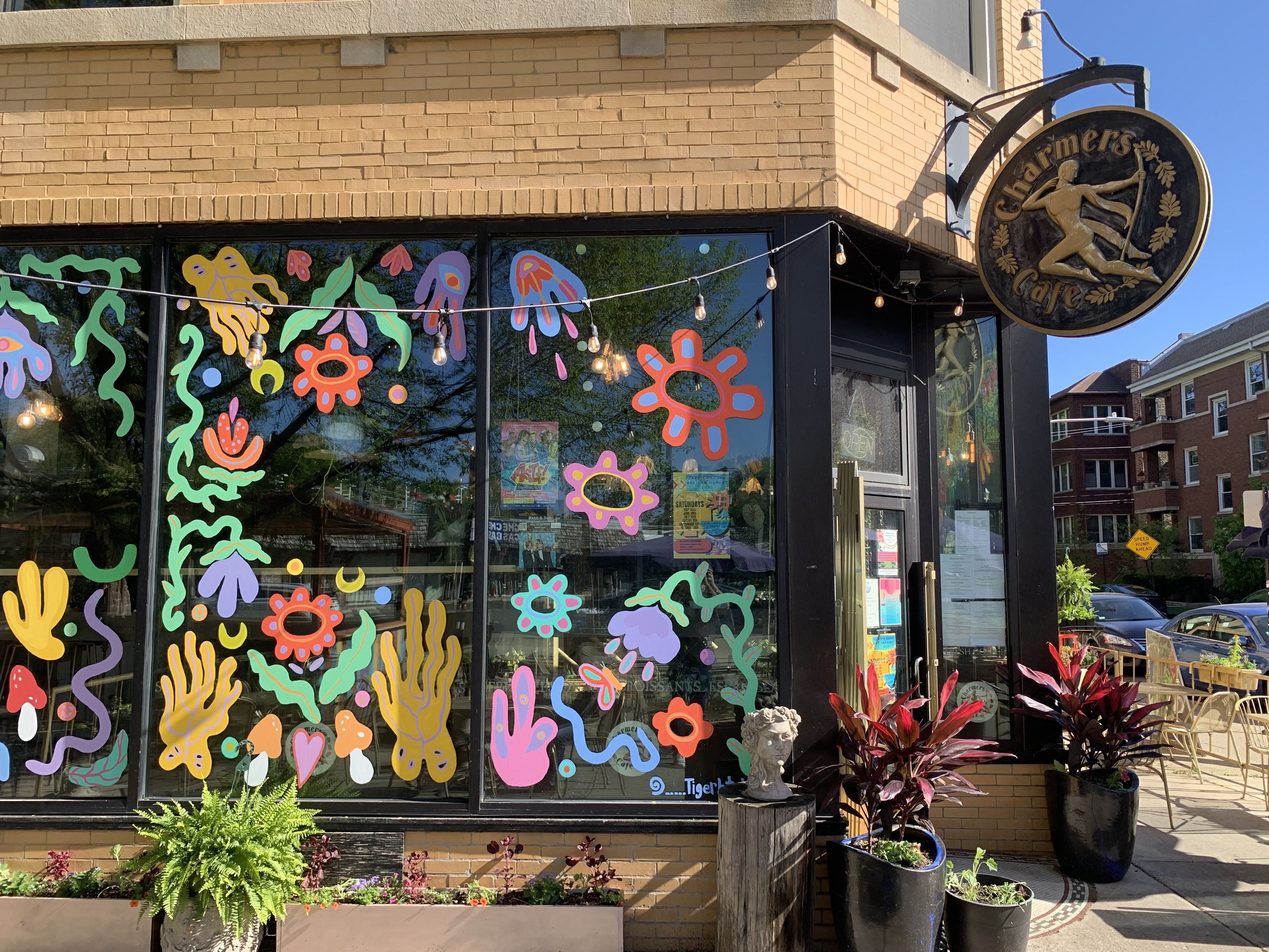 Photo of the outside of a restaurant, painted with flowers on the windows. 