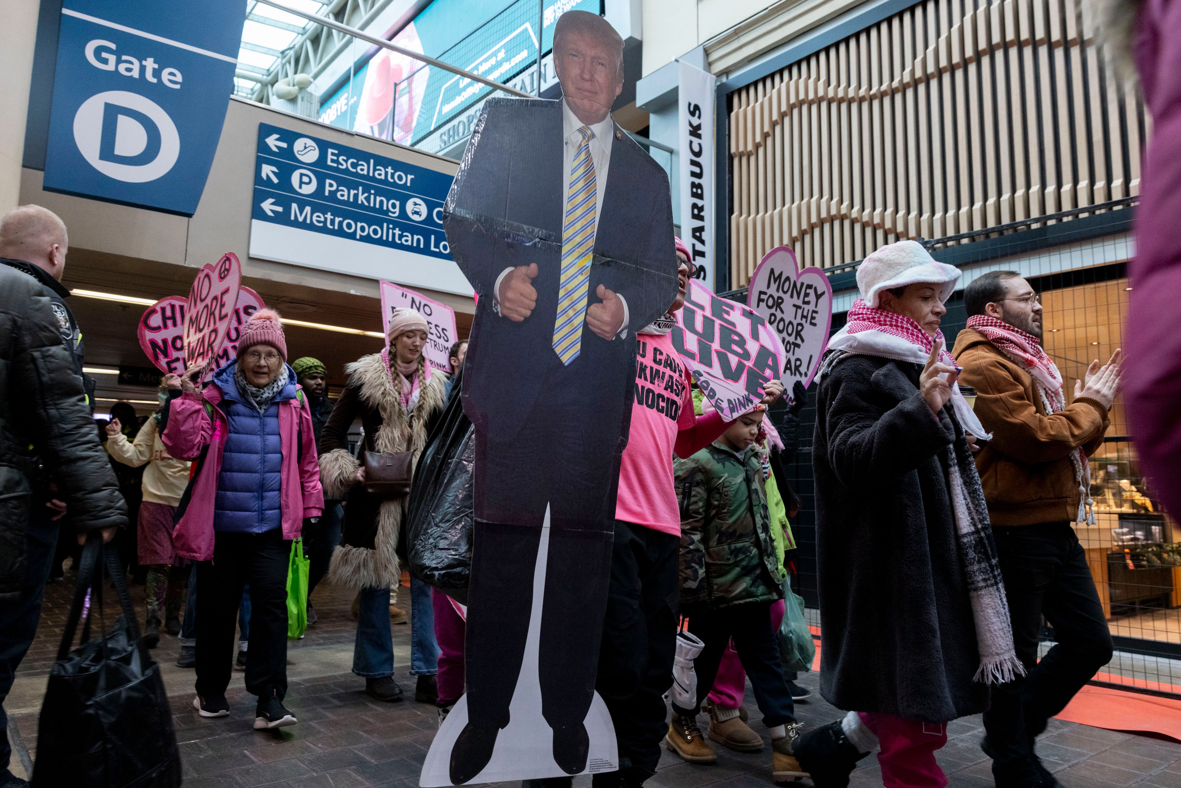 A crowd walks with a President Donald Trump poster in Union Station in Washington, D.C.