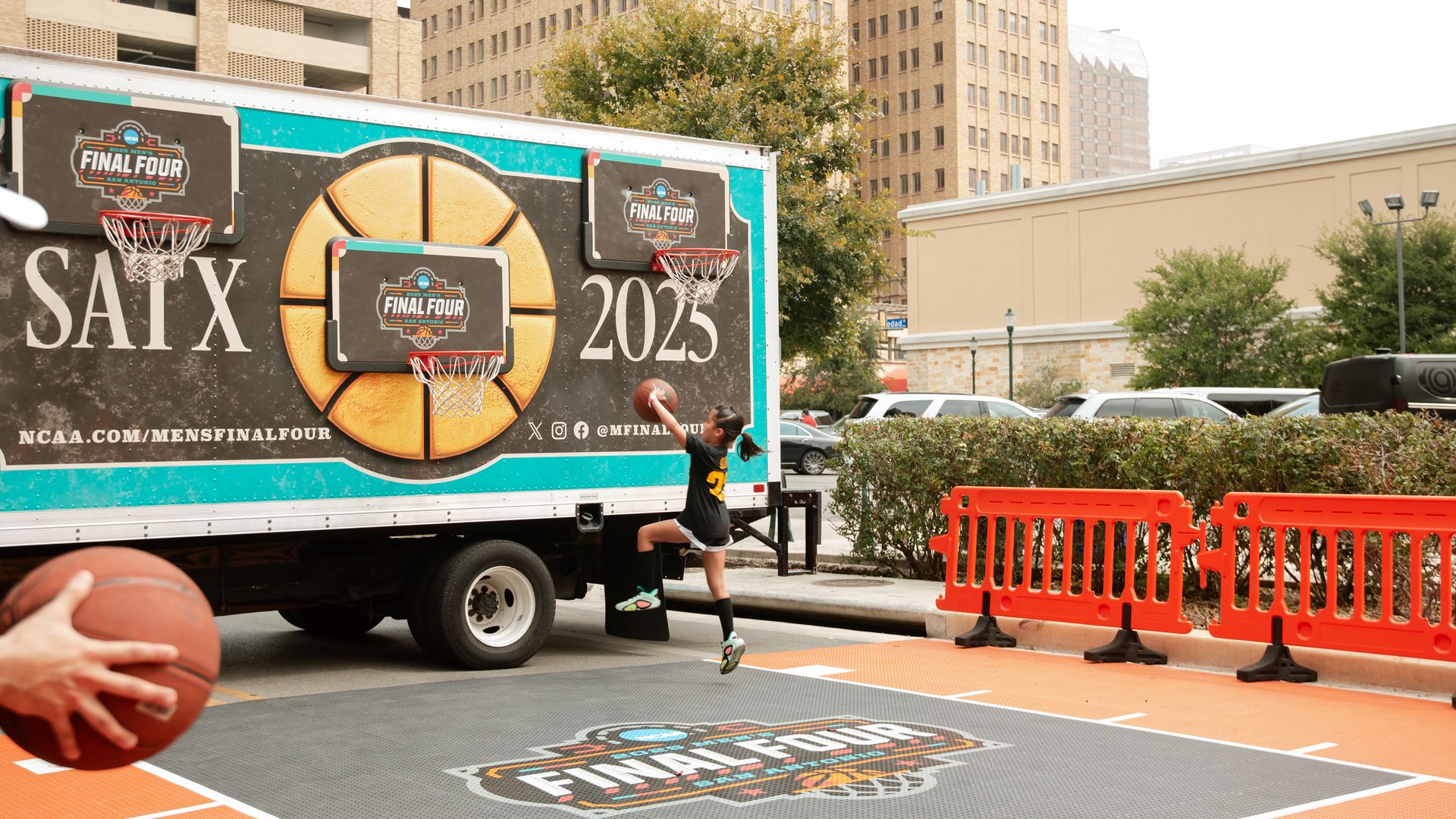 A child plays basketball on an outdoor court.