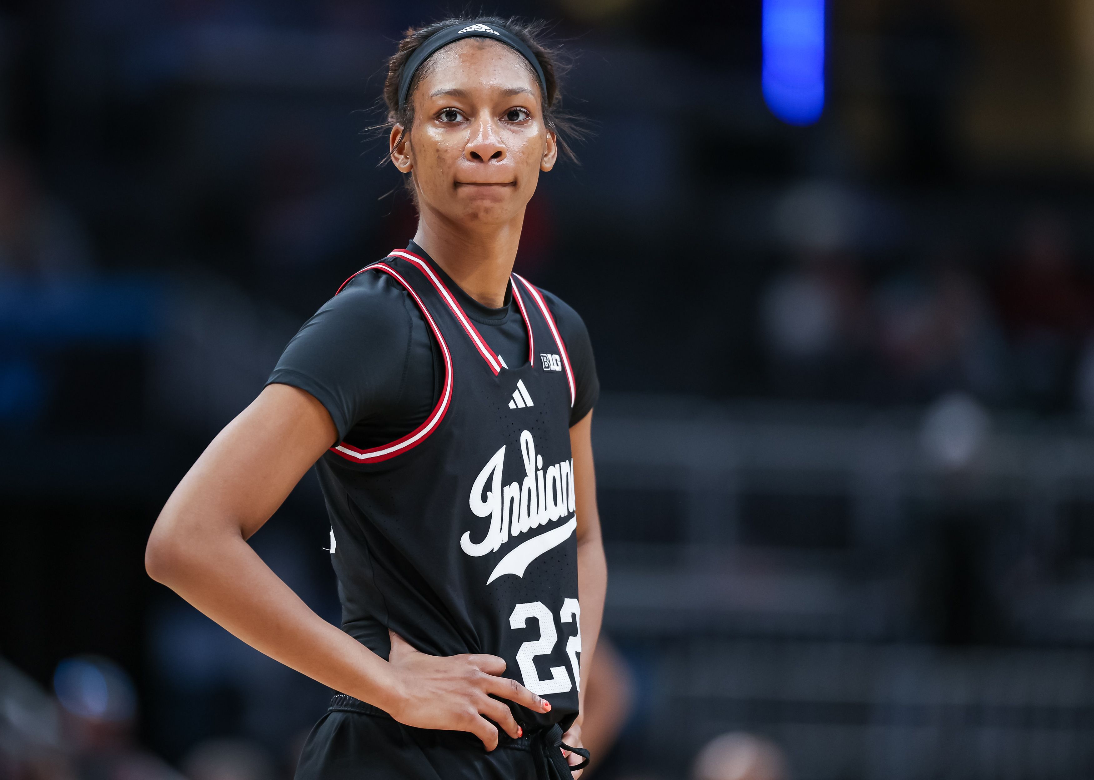 Photo of a woman in a basketball uniform on a court.