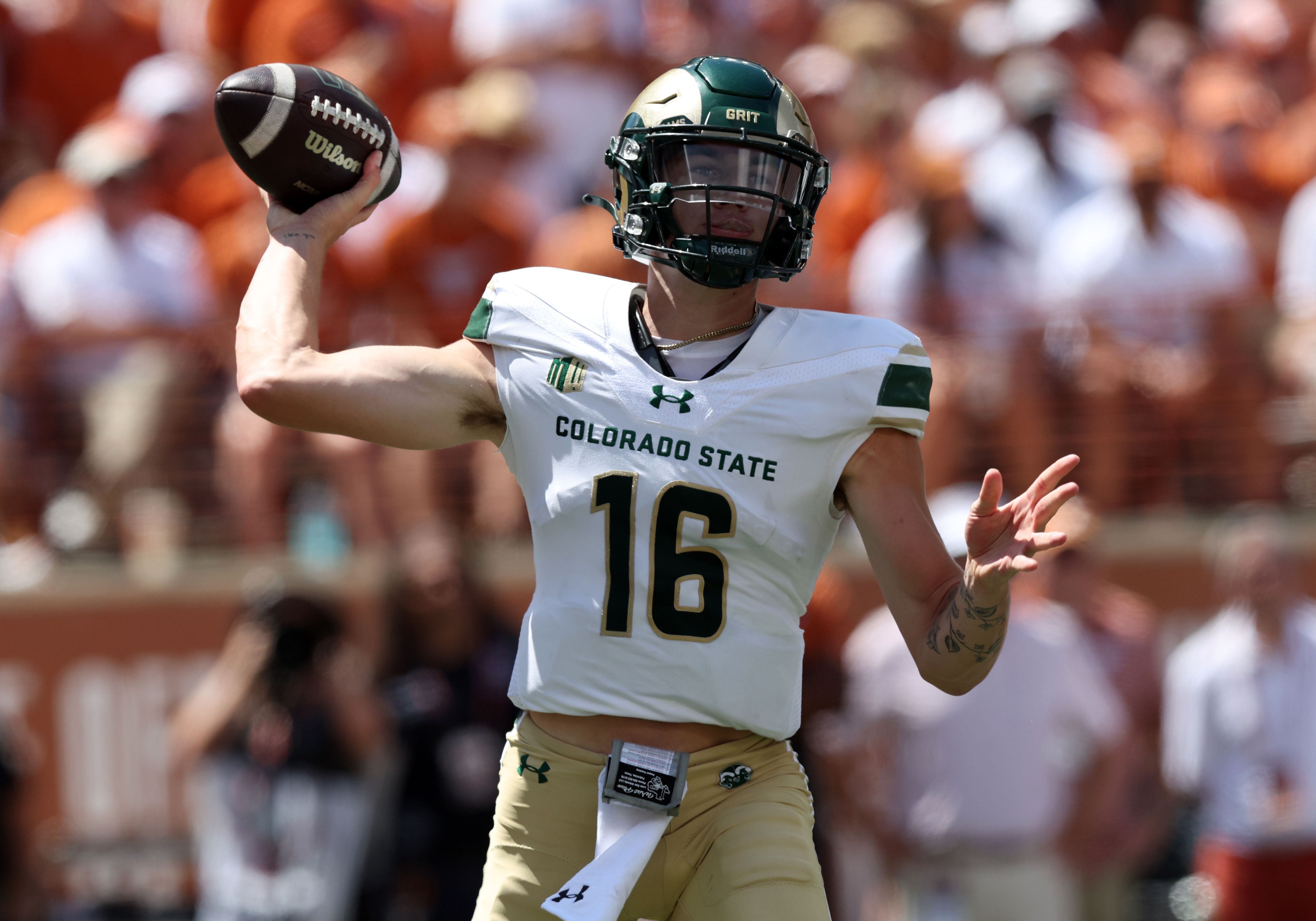 A man in a white football uniform throws a ball