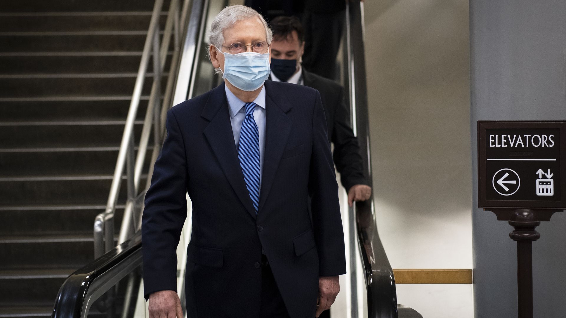 Mitch McConnell stands in front of a staircase