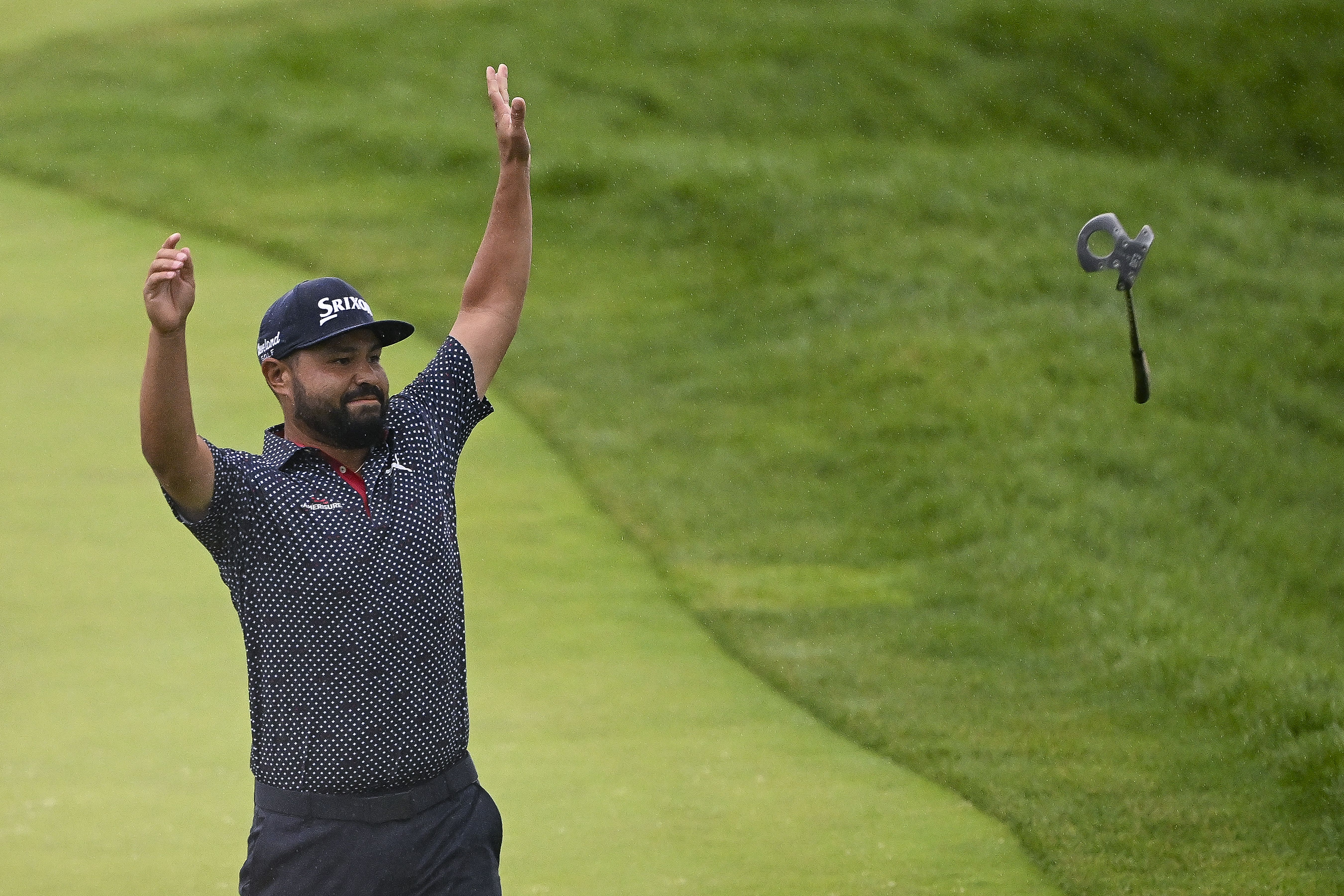 Spaun throws his putter in celebration on the 18th green.