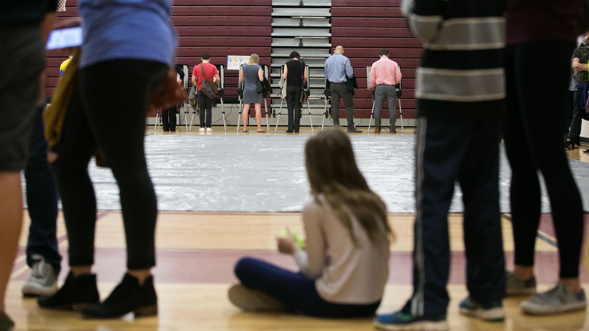 Voters in a gymnasium line up to vote.